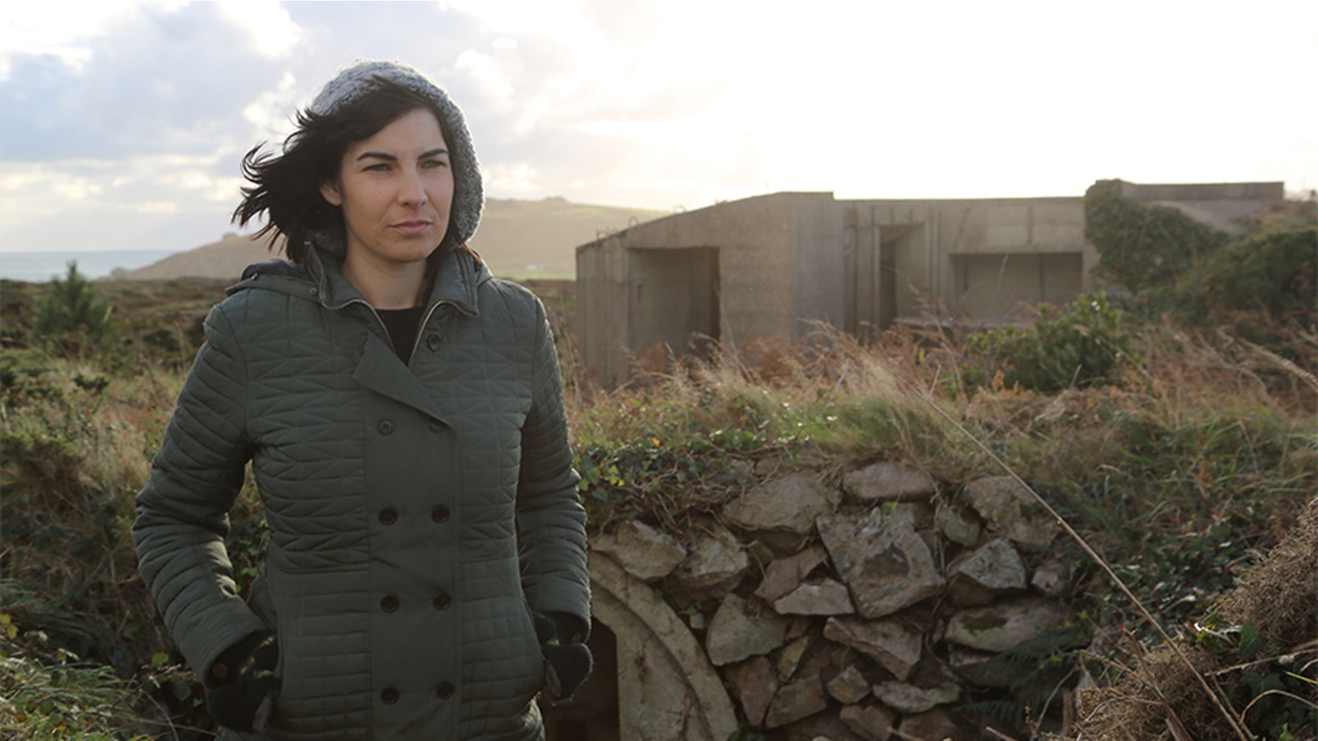Professor Caroline Sturdy Colls standing next to concrete fortification on Alderney. — SNI/SI Networks L.L.C.