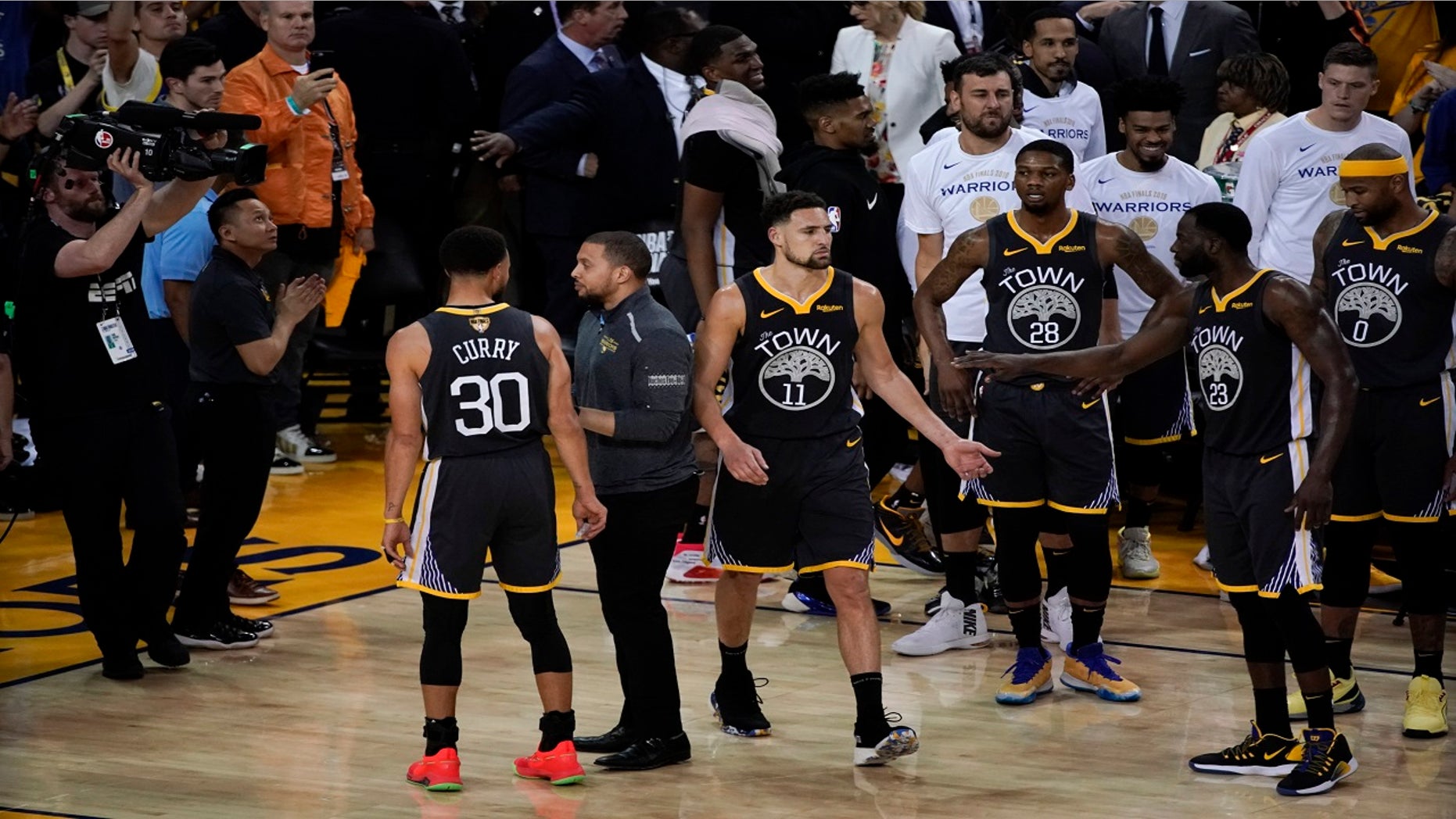 Golden State Warriors guard Klay Thompson (11) is greeted by teammates after walking back onto the court to shoot free throws after an injury against the Toronto Raptors during the second half of Game 6.