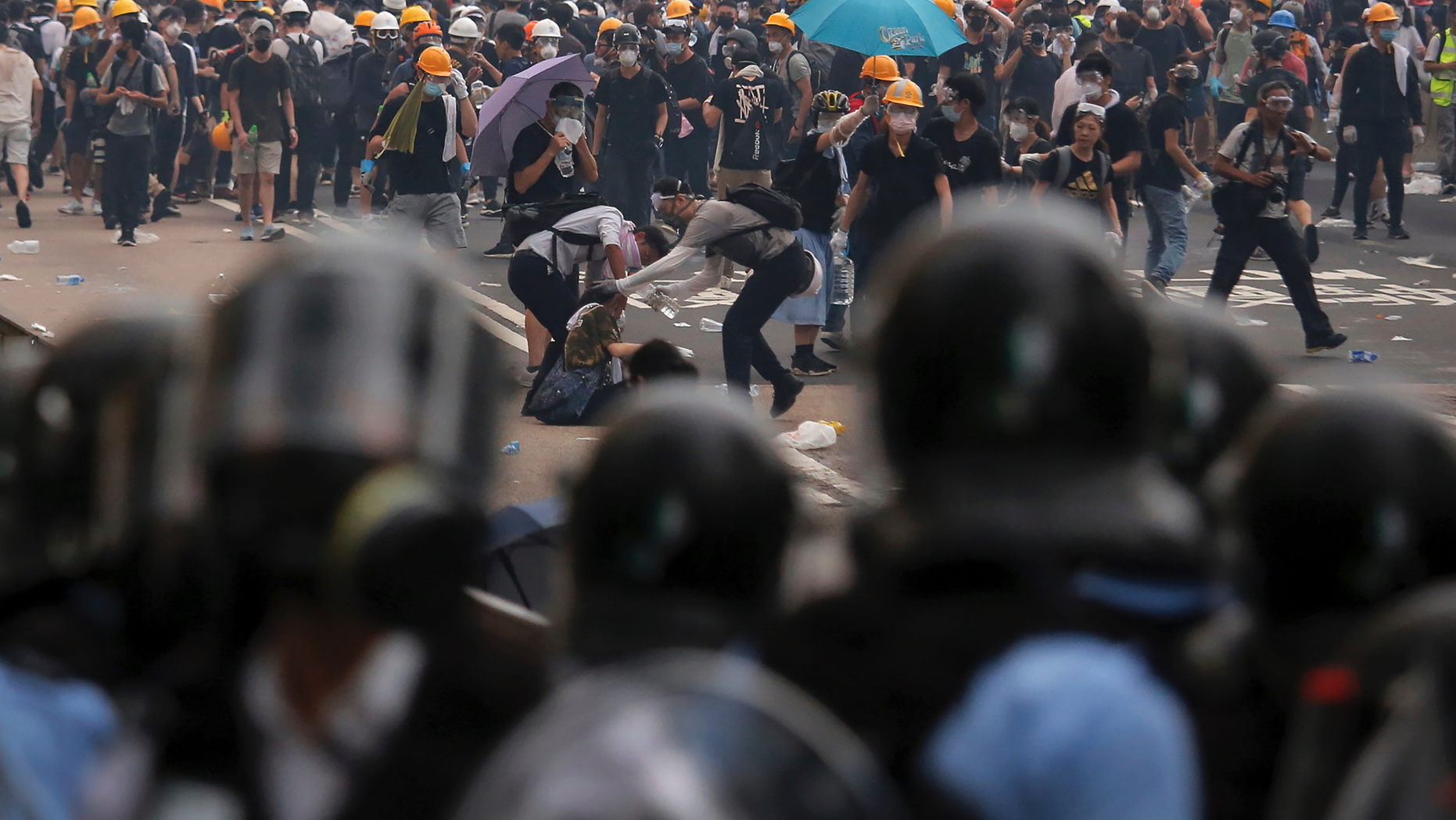 Protesters help a fallen person after clashing with riot police during a massive demonstration outside the Legislative Council in Hong Kong, Wednesday, June 12, 2019. Hong Kong police fired tear gas and rubber bullets at protesters who had massed outside government headquarters Wednesday in opposition to a proposed extradition bill that has become a lightning rod for concerns over greater Chinese control and erosion of civil liberties in the territory. (AP Photo/Kin Cheung)