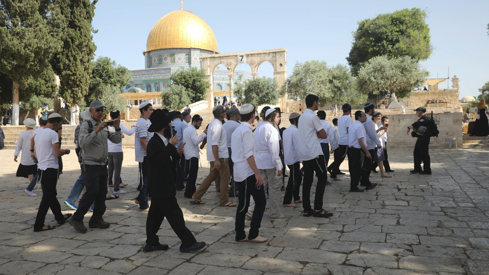 Israeli police officers escort a group of religious Jews near the Dome of the Rock Mosque in the Al Aqsa Mosque compound in Jerusalem's old city, Sunday, June 2, 2019. (AP Photo/Mahmoud Illean)