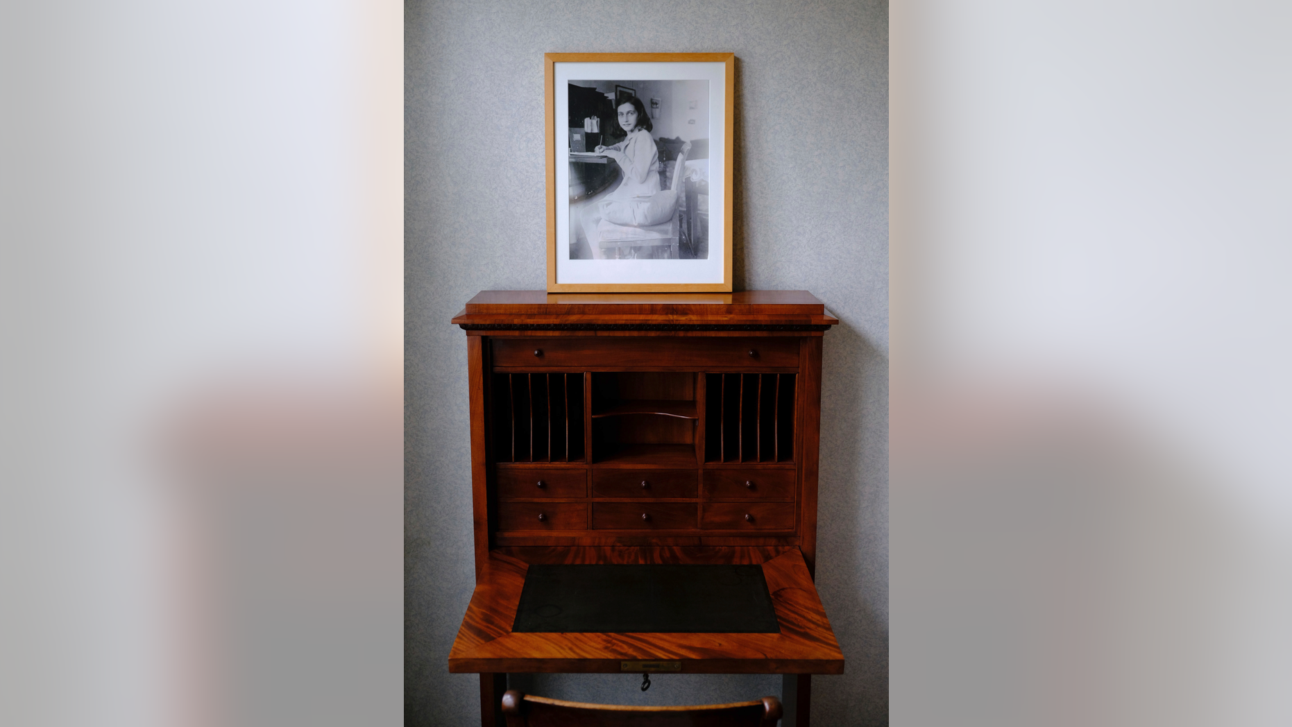 A photo of Anne Frank stands on a replica of the writing desk she once used in her family's former apartment in Amsterdam, during an event to mark what would have been Anne Frank's 90th birthday, in Amsterdam, Netherlands, Wednesday, June 12, 2019. On the day Anne Frank would have turned 90, the museum dedicated to keeping alive her story has brought together schoolchildren and two of the Jewish diarist's friends at the apartment where she lived with her family before going into hiding from Nazis who occupied the Netherlands during World War II. (AP Photo/Michael C. Corder)