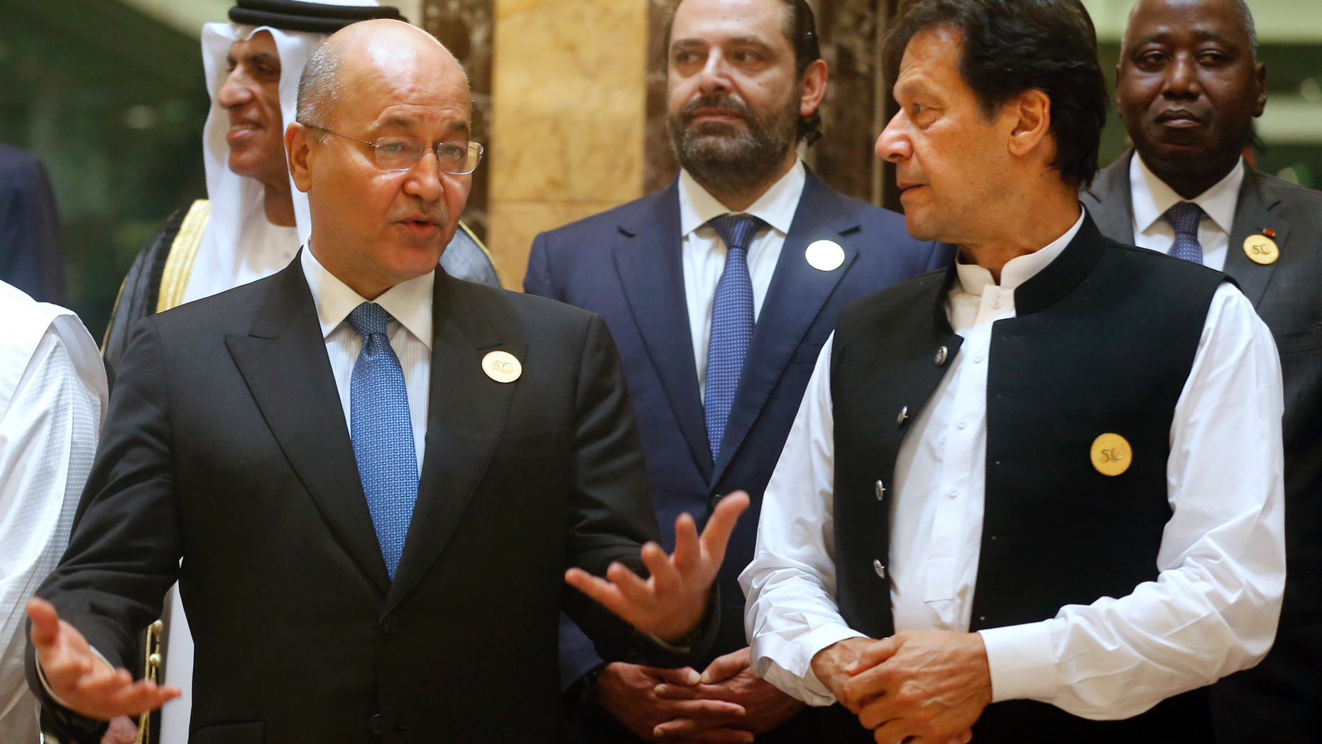 Pakistan's Prime Minister Imran Khan, right, listens to Iraq's President Barham Salih during a group picture ahead of Islamic Summit of the Organization of Islamic Cooperation (OIC) in Mecca, Saudi Arabia, early Saturday, June 1, 2019. Muslim leaders from some 57 nations gathered in Islam's holiest city of Mecca late Friday to discuss a breadth of critical issues ranging from a spike in tensions in the Persian Gulf, to Palestinian statehood, the plight of Rohingya refugees and the growing threat of Islamophobia. (AP Photo/Amr Nabil)