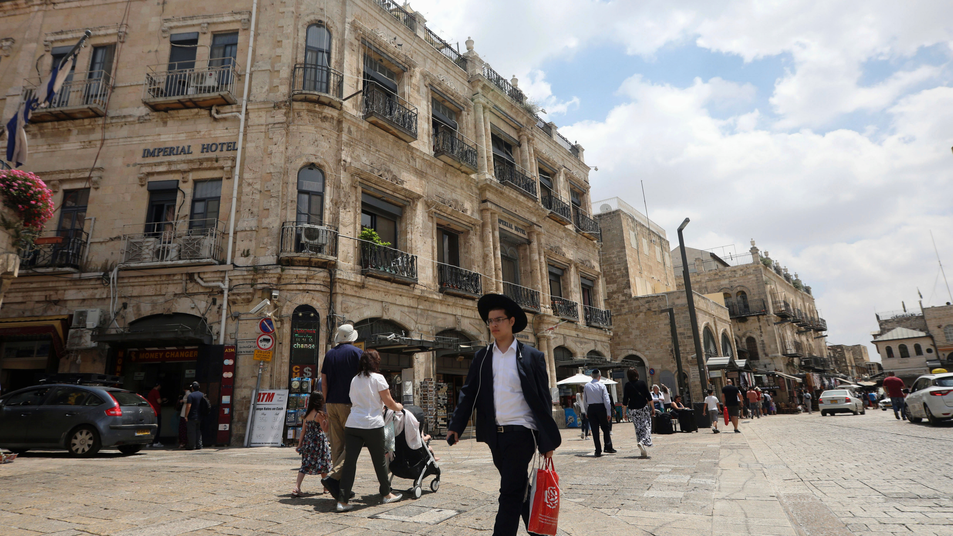 People walk past the Palestinian-run Imperial Hotel, that was part of a legal battle, in Jerusalem's Old City, Thursday, June 13, 2019. Israel's Supreme Court has ruled against the Greek Orthodox Church in a long-running legal battle over the sale of three properties in predominantly Palestinian parts of Jerusalem's Old City to a Jewish settler group. (AP Photo/Mahmoud Illean)