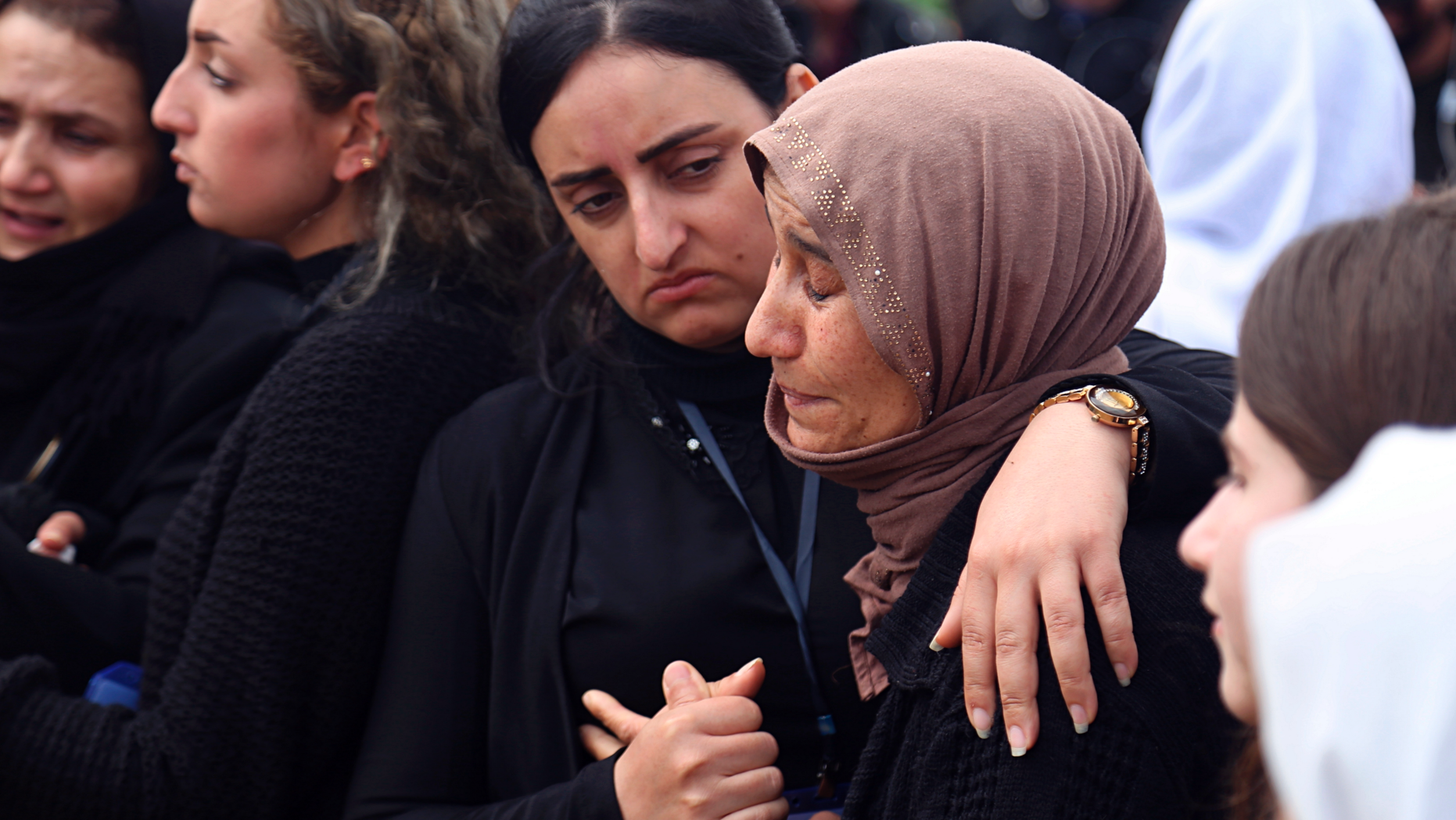 FILE - In this March 15, 2019 file photo, Iraqi Yazidi women mourn during the exhumation process of a mass grave in Iraq's northwestern region of Sinjar. The head of Iraq's forensics administration said Sunday, June 9, 2019, that his office will begin DNA testing to identify the remains of 141 bodies found in mass graves, believed to contain the Yazidi victims of the Islamic State group's campaign of massacres five years ago. (AP Photo/Farid Abdulwahed, File)