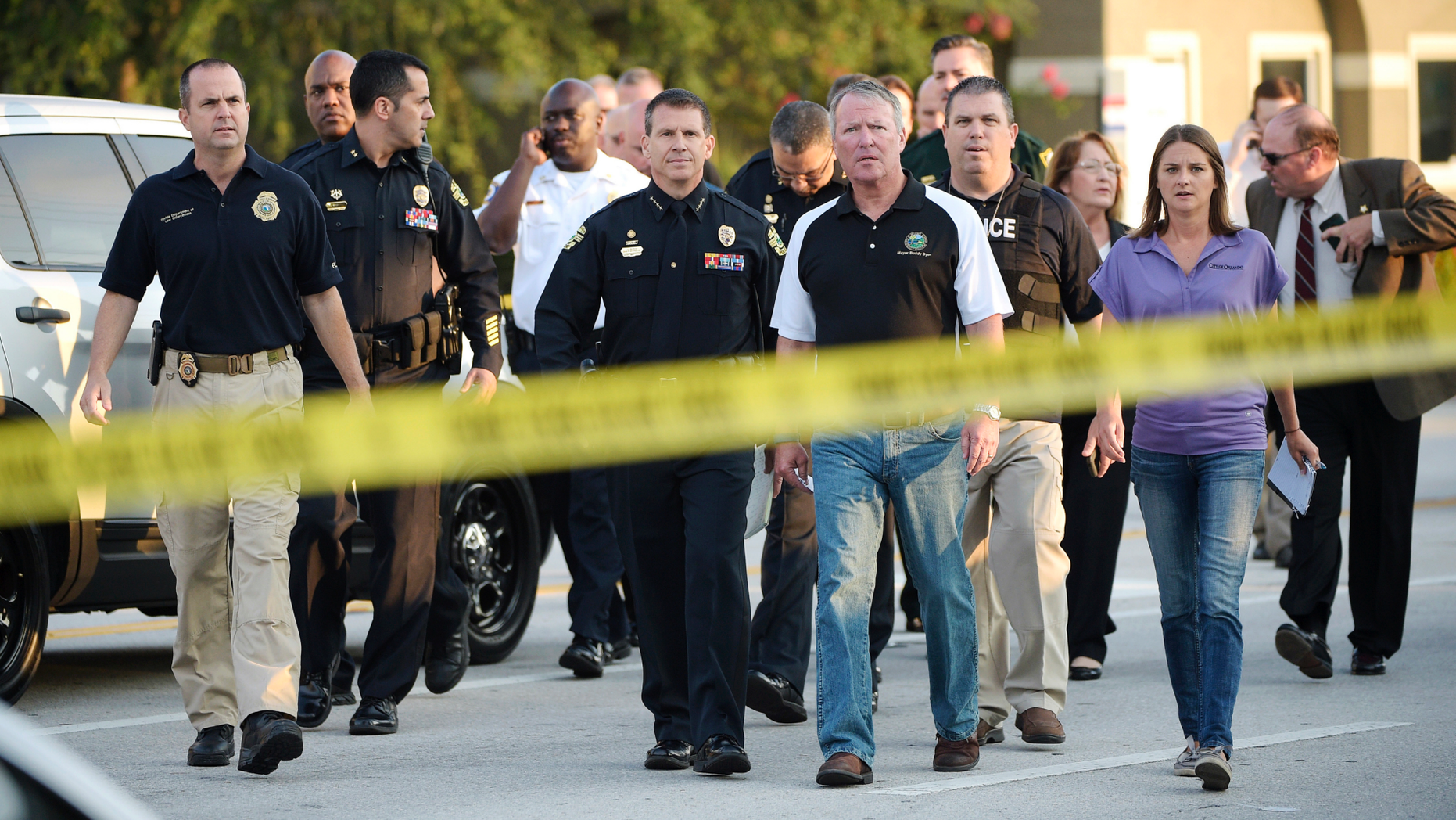 FILE - In this Sunday, June 12, 2016 file photo, Mayor Buddy Dyer, center right, and then-Police Chief John Mina, center left, arrive for a news conference after the mass shooting at the Pulse Orlando nightclub in Orlando, Fla. Mina, now the Orange County, Fla., sheriff, says after the attack, police officers were equipped with another layer of body armor that stops rifle rounds. (AP Photo/Phelan M. Ebenhack)