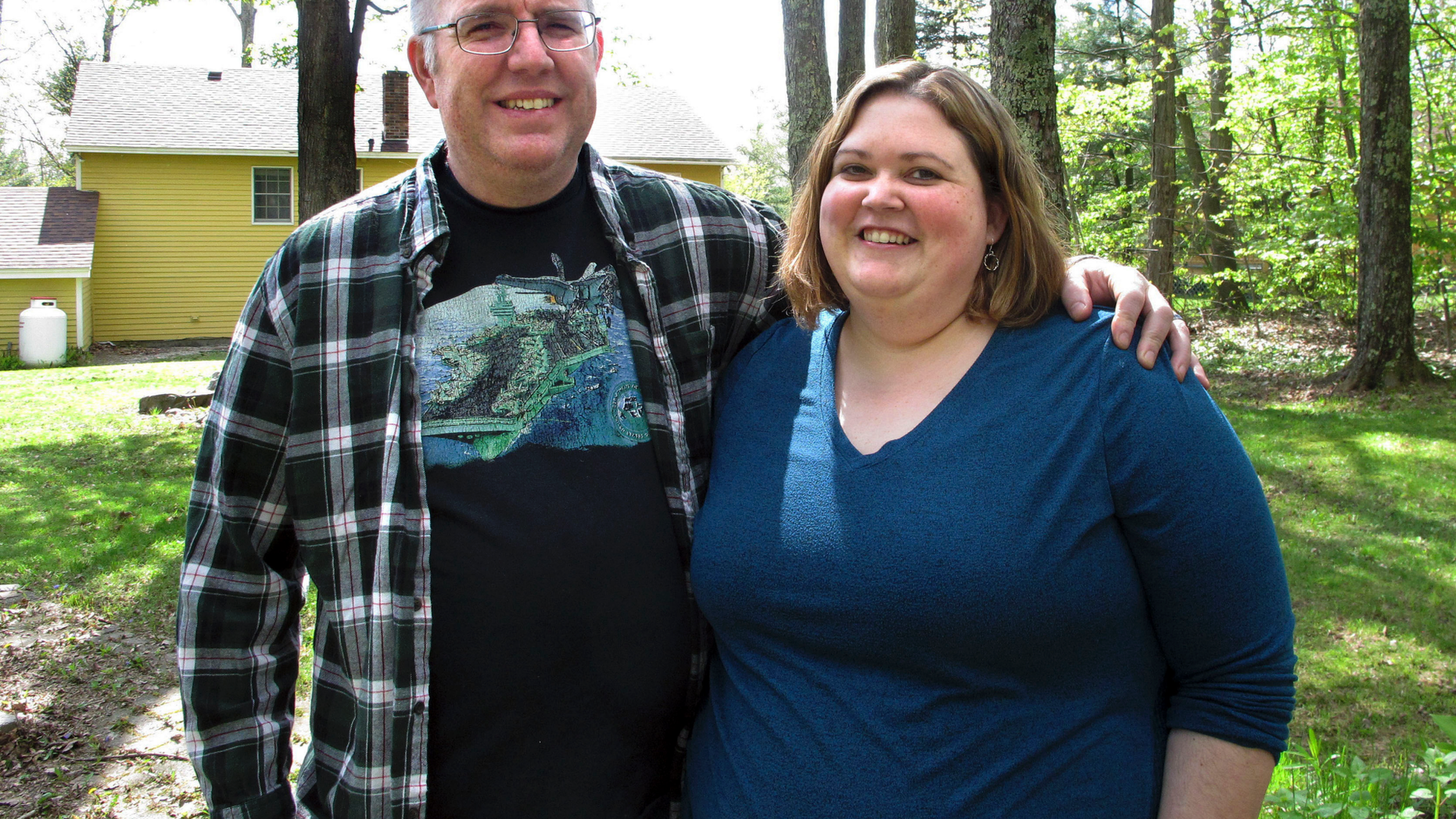In this May 15, 2019, photo, Jonathan and Beth Dow stand in their backyard in Bennington, Vt. The couple recently moved to Vermont from Colorado through a Vermont program to attract new residents. (AP Photo/Lisa Rathke)