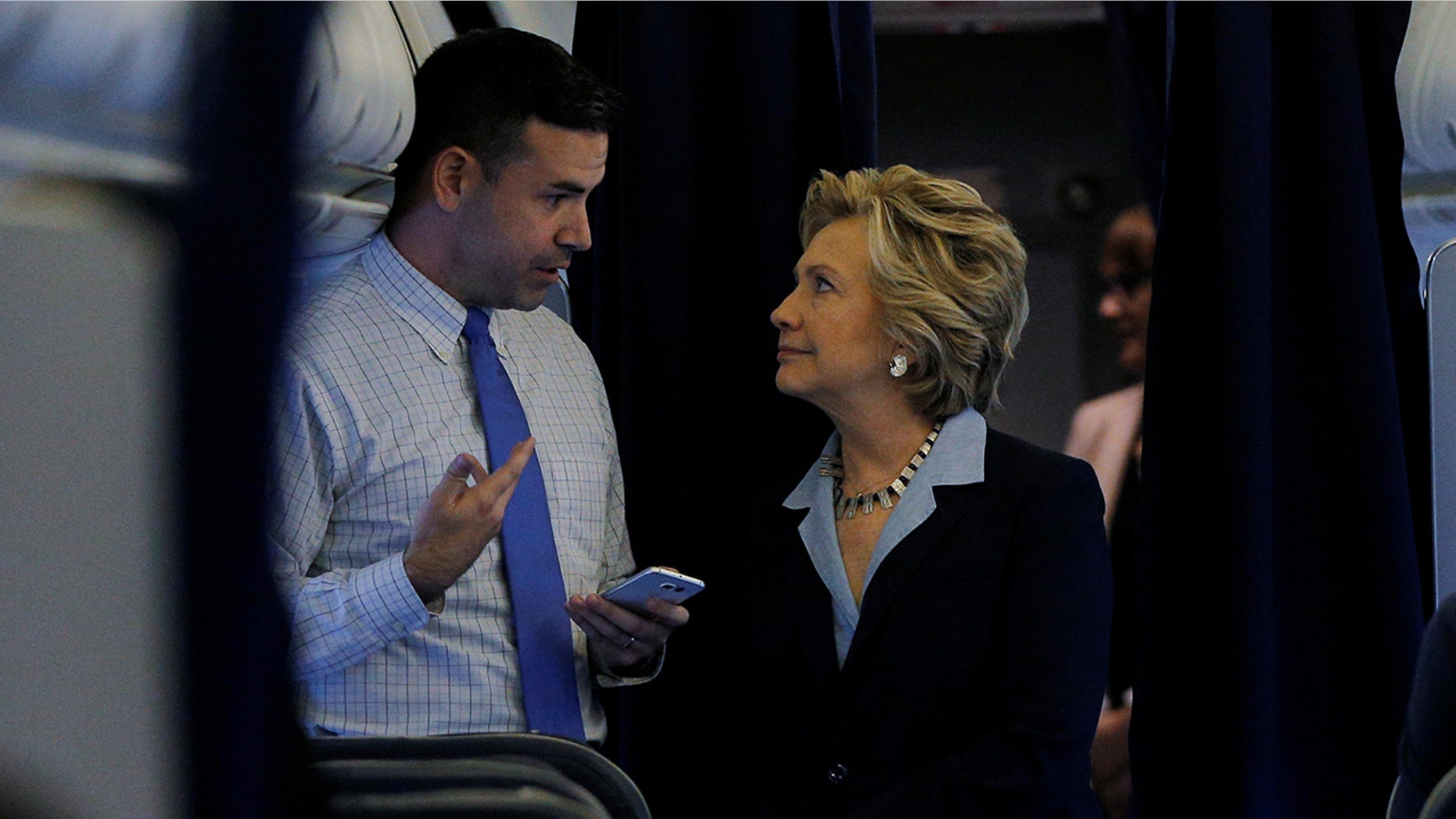 Hillary Clinton and national press secretary Brian Fallon talking onboard her campaign plane in White Plains, New York, in October 2016.