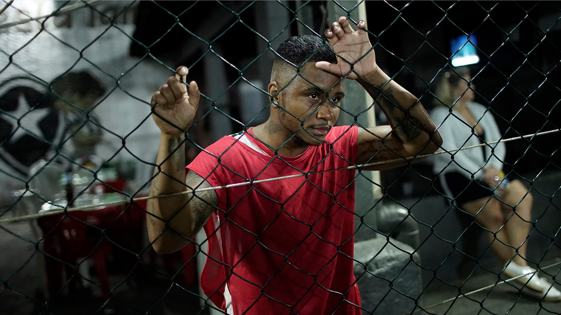 In this May 27, 2019 photo, Bruno dos Santos watches a soccer game between his Bigtboys transgender men's team and the Alligaytors, a gay men's team in Rio de Janeiro, Brazil. For the two dozen Bigtboys players, the pitch is also one of the few places where they feel at ease and can talk about their experiences, good and bad, without fear. (AP Photo/Silvia Izquierdo)