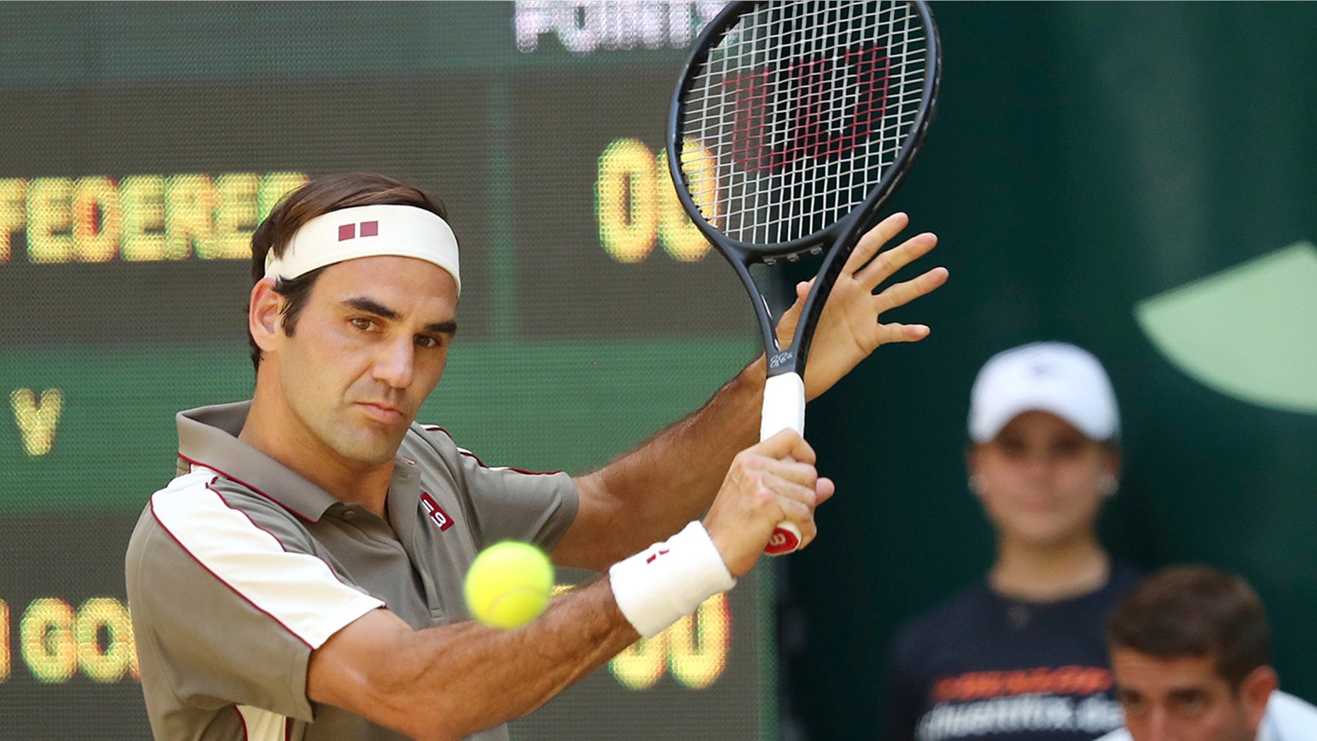 Swiss Roger Federer hits a backhand in the tennis ATP final against Belgium David Goffin in Halle, Germany, Sunday, June 23, 2019. (Friso Gentsch/dpa via AP)