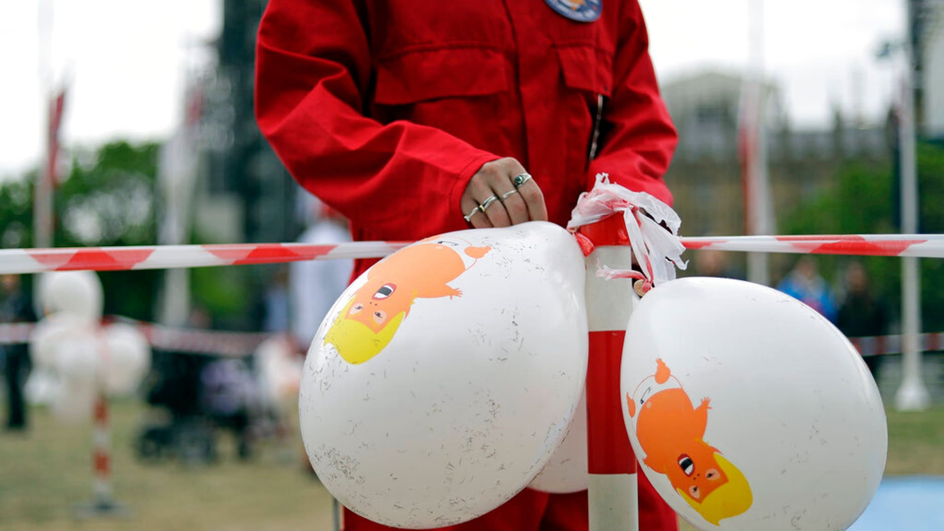 A demonstrator fixes balloons to an area where they will inflate the 'Trump Baby' giant balloon in Parliament Square in central London as people start to gather to demonstrate against the state visit of President Donald Trump, Tuesday, June 4, 2019. (AP Photo/Matt Dunham)