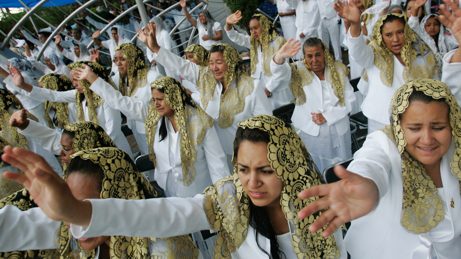FILE - In this Aug. 14, 2009 file photo, worshippers raise their hands at La Luz Del Mundo,