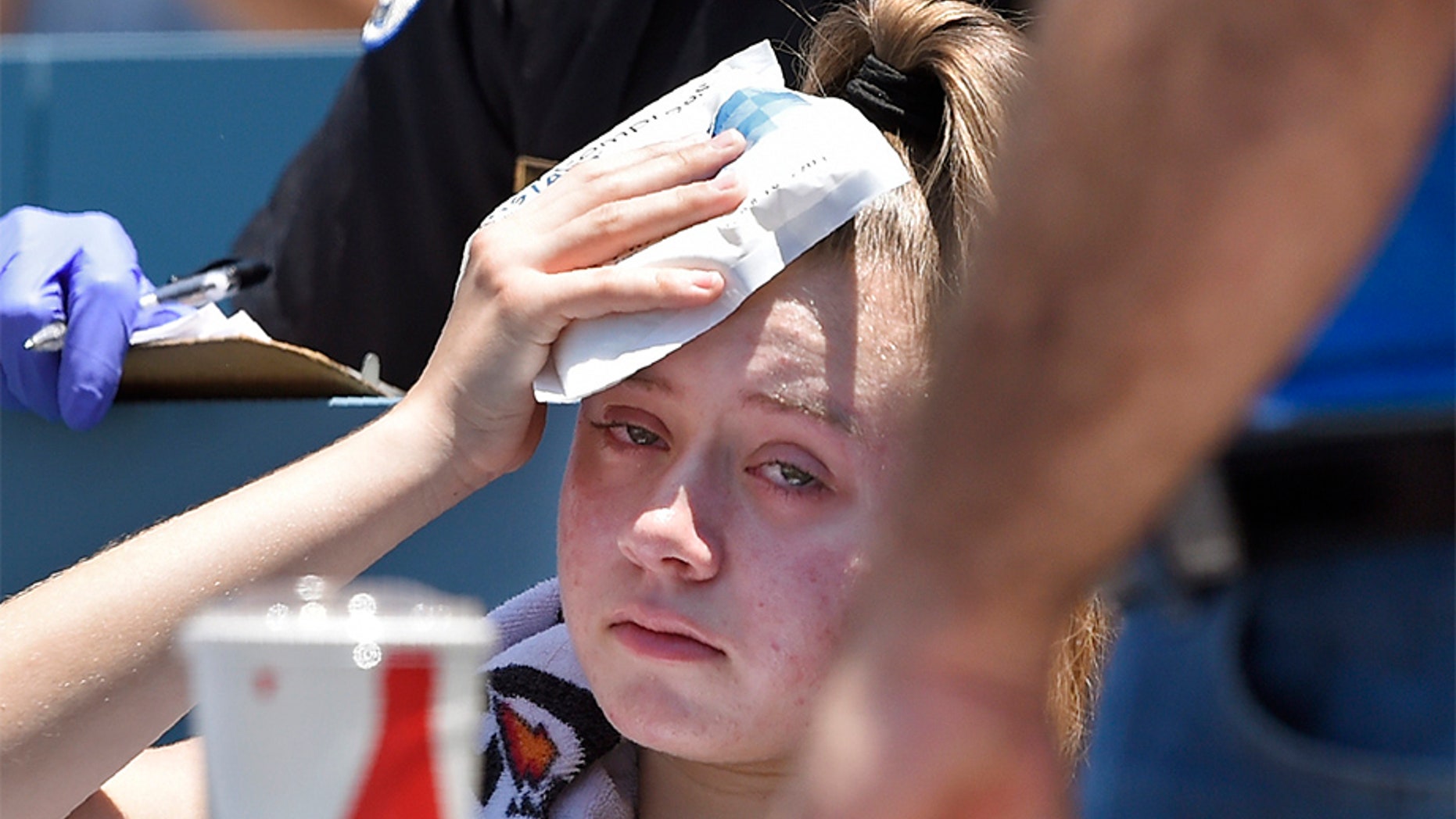 A young fan holds ice to her hit with a foul ball hit by Los Angeles Dodgers' Cody Bellinger during the first inning of a baseball game against the Colorado Rockies on Sunday.