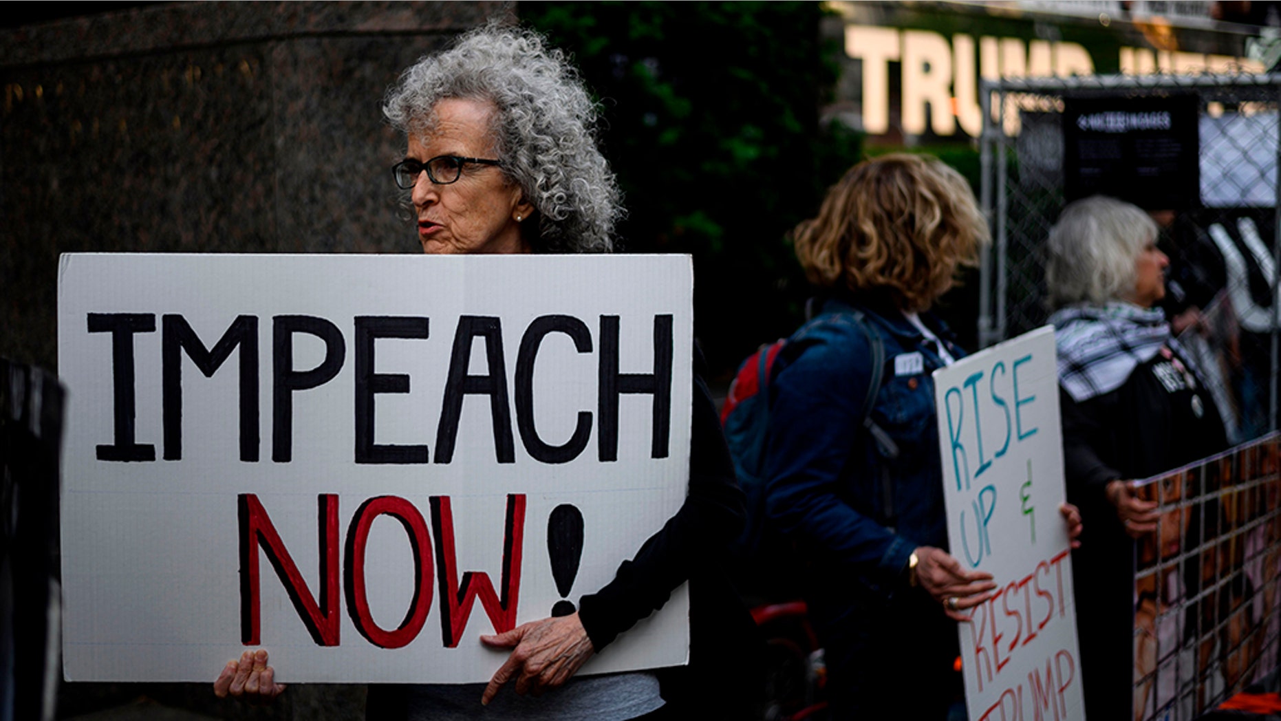 A demonstrator with a sign reading "Impeach now" takes part in Trumps Birthday Protest in front of the Trump International Tower, June 14, 2019 in New York City. - A group of activists protested against his immigration policy. (JOHANNES EISELE/AFP/Getty Images)