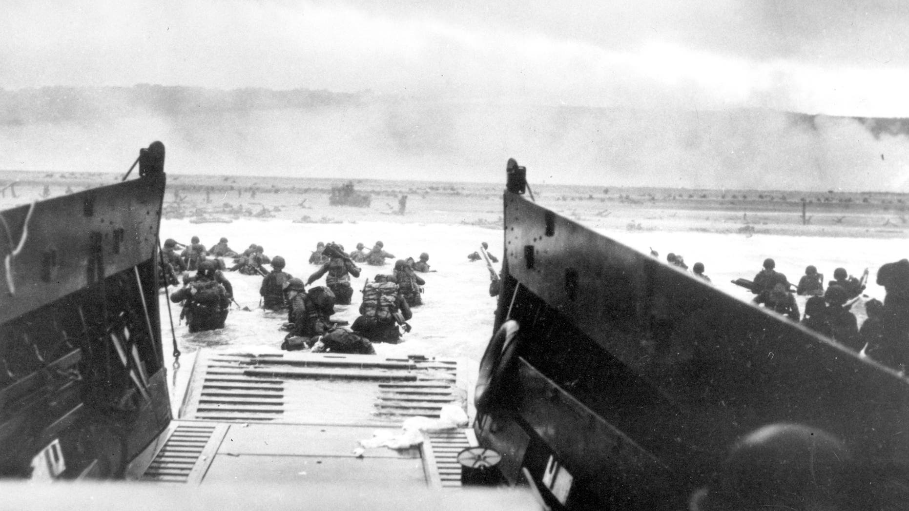 FILE - In this June 8, 1944, file photo, under heavy German machine gun fire, American infantrymen wade ashore off the ramp of a Coast Guard landing craft during the invasion of the French coast of Normandy in World War II. June 6, 2019, marks the 75th anniversary of D-Day, the assault that began the liberation of France and Europe from German occupation, leading to the end World War II.