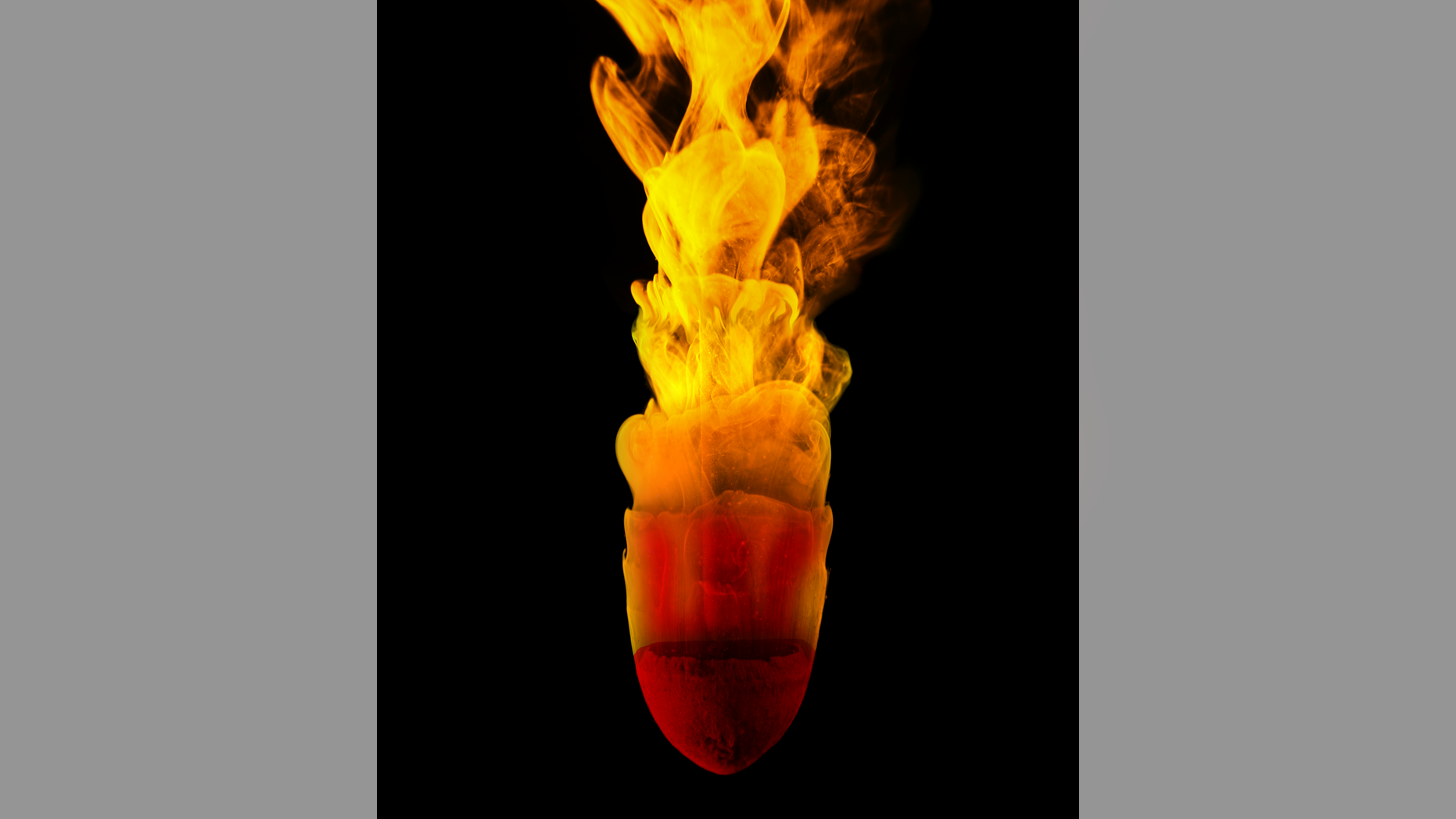 A chunk of clay, attached to a rod, deforms in rushing water as part of one experiment.