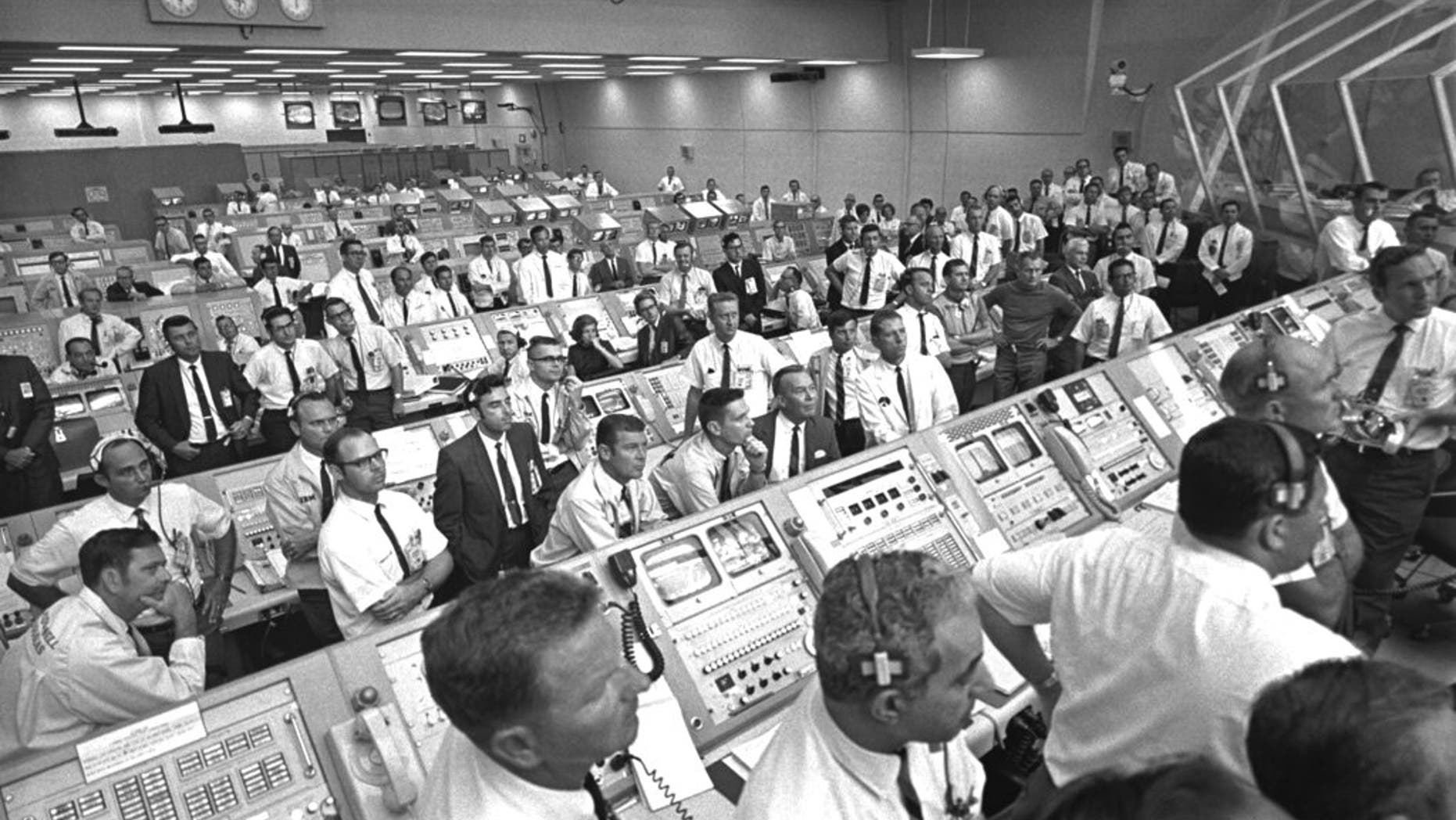 This July 1969 photo provided by NASA shows launch controllers in the firing room at the Kennedy Space Center in Florida during the Apollo 11 mission to the moon. In the third row from foreground at center is JoAnn Morgan, the first female launch controller. "I was there. I wasn't going anywhere. I had a real passion for it," Morgan said in a July 2019 interview. "Finally, 99 percent of them accepted that 'JoAnn's here and we're stuck with her.' " (NASA via AP)