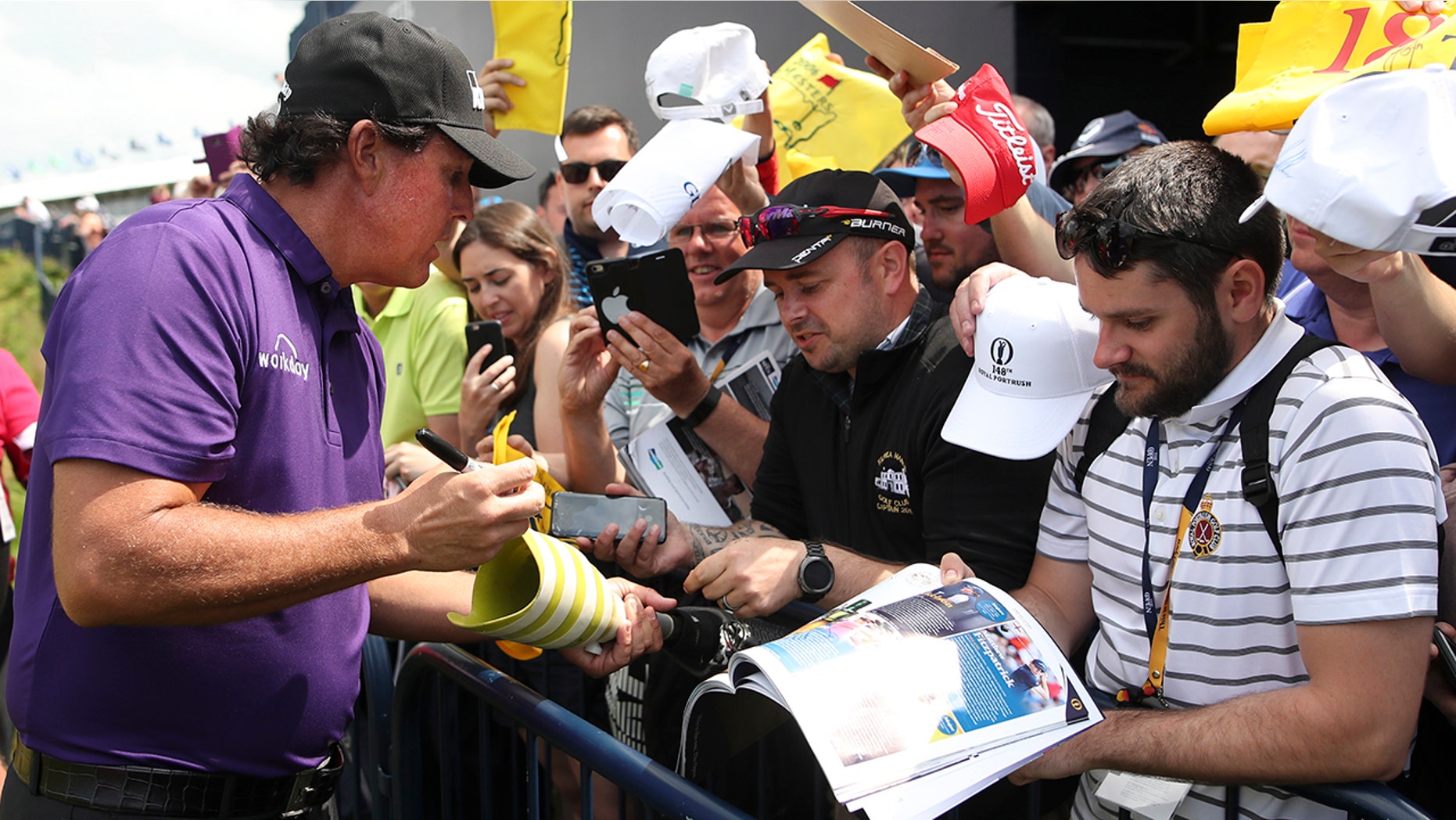 Phil Mickelson of the United States signs autographs on the 18th fairway during a practice round ahead of the start of the British Open golf championships at Royal Portrush in Northern Ireland, Tuesday, July 16, 2019. The British Open starts Thursday. (AP Photo/Peter Morrison)