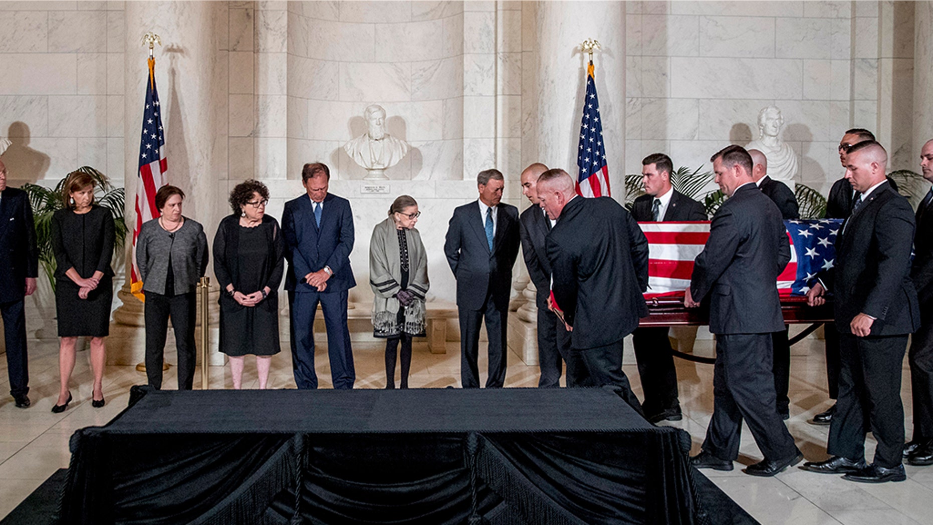 From left, retired Associate Justice Anthony Kennedy, Ashley Kavanaugh, the wife of Associate Justice Brett Kavanaugh, Associate Justice Elena Kagan, Associate Justice Sonia Sotomayor, Associate Justice Samuel Alito, Associate Justice Ruth Bader Ginsburg, and Chief Justice John Roberts watch as the casket of late Supreme Court Justice John Paul Stevens is carried into the Great Hall of the Supreme Court in Washington, Monday, July 22, 2019. (AP Photo/Andrew Harnik, pool)