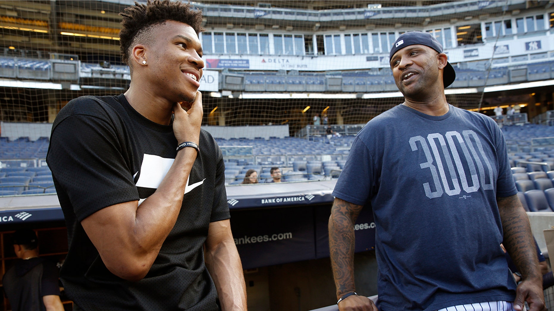 Milwaukee Bucks forward and 2019 NBA Most Valuable Player Giannis Antetokounmpo, left, talks to New York Yankees starting pitcher CC Sabathia before a baseball game between the Yankees and the Tampa Bay Rays, Monday, July 15, 2019, in New York. (AP Photo/Kathy Willens)