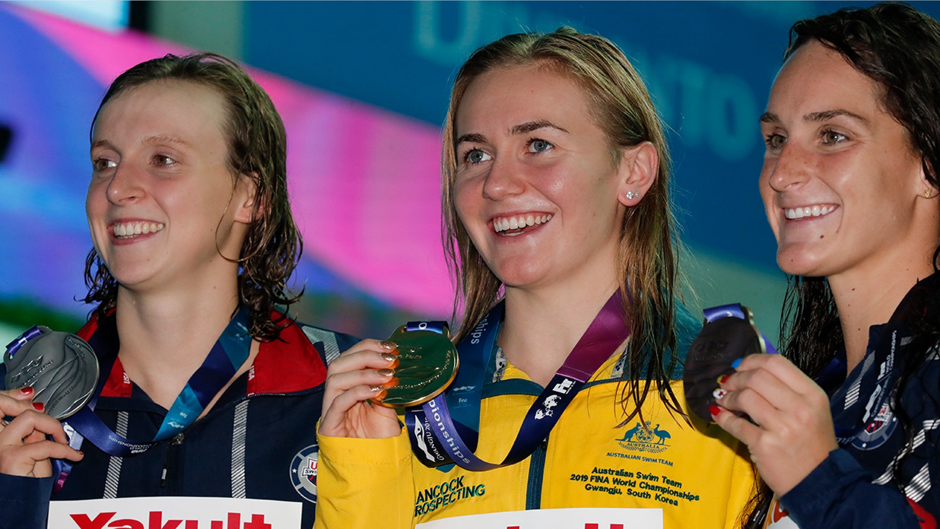 Gold medalist Australia's Ariane Titmus, centre, stands with silver medalist United States' Katie Ledecky and her compatriot and bronze medalist Leah Smith, right, following the women's 400m freestyle final at the World Swimming Championships in Gwangju, South Korea, Sunday, July 21, 2019.(AP Photo/Lee Jin-man)