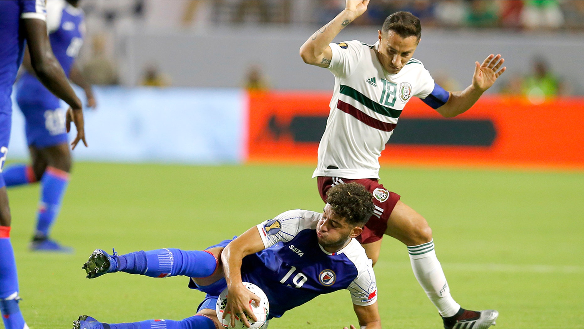 Haiti midfielder Steeven Saba and Mexico midfielder Andres Guardado (18) fight for the ball during the first half of a CONCACAF Gold Cup soccer match, Tuesday, July 2, 2019, in Glendale, Ariz. (AP Photo/Rick Scuteri)