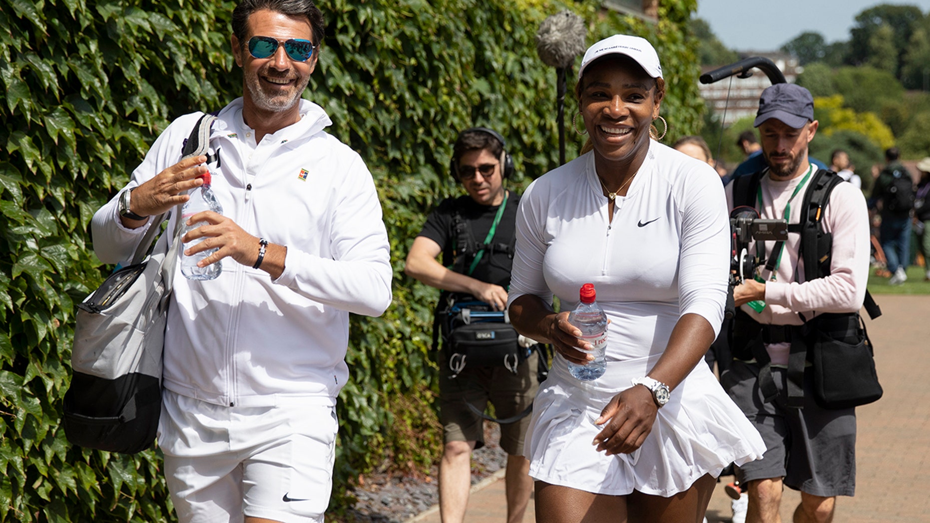 Serena Williams of USA and her coach Patrick Mouratoglou walk on after a training session at the All England Lawn Tennis Championships in Wimbledon London on Friday