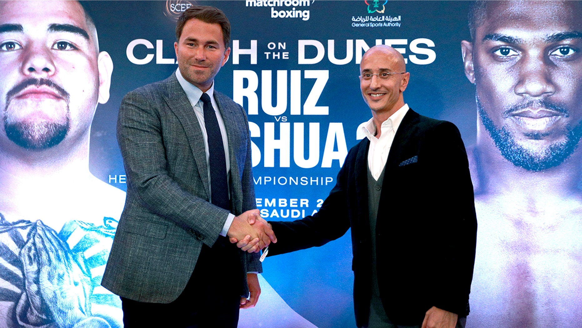 Boxing promoters Eddie Hearn and managing partner of Skill Challenge Entertainment Omar Khalil shake hands, during a press conference at The Savoy Hotel, London, Monday, Aug. 12, 2019. Anthony Joshua's promoters say his world heavyweight title rematch against Andy Ruiz Jr. will take place in Diriyah, Saudi Arabia, on Dec. 7. (Ian Walton/PA via AP)
