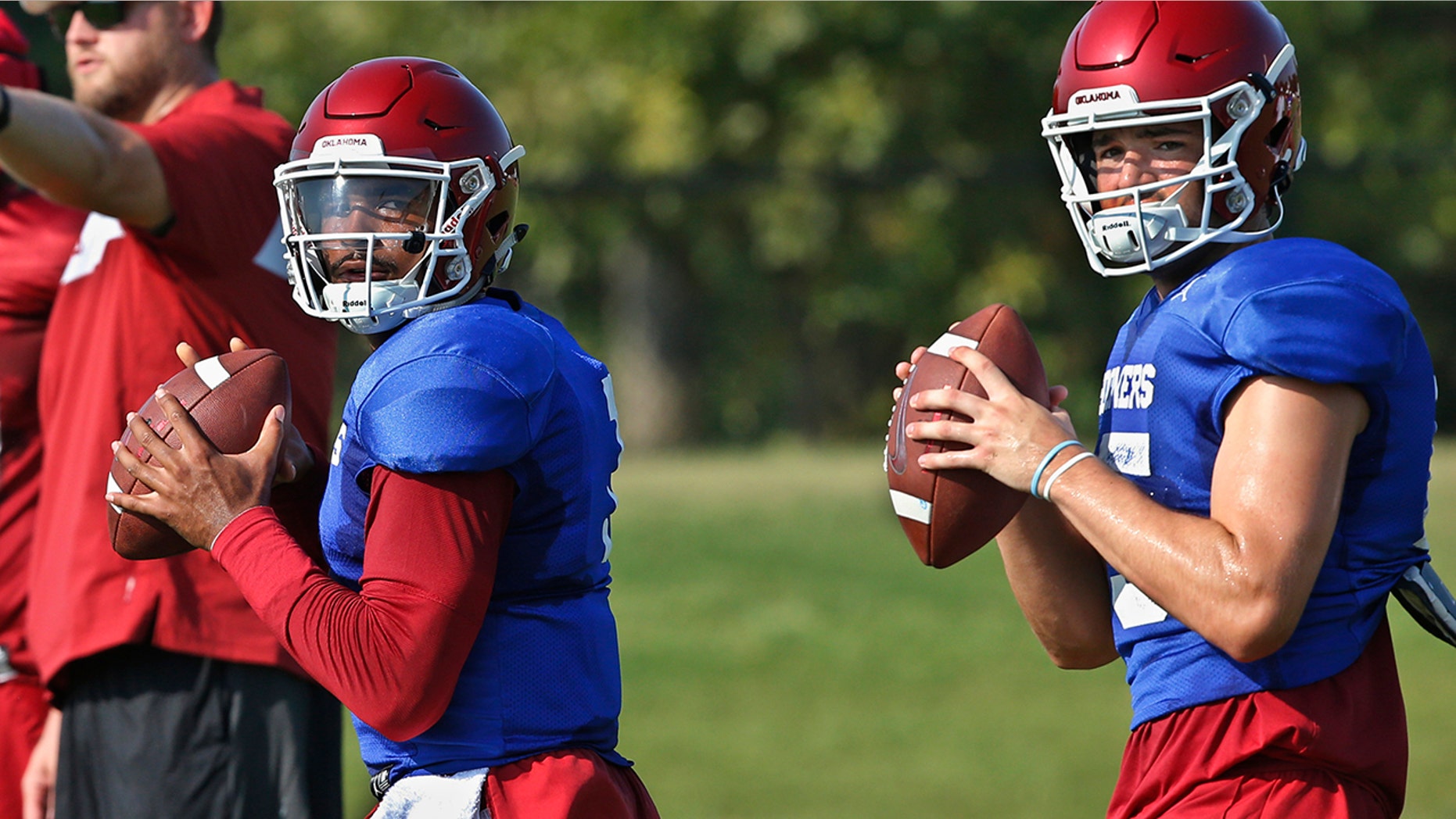 FILE - In this Monday, Aug. 5, 2019, file photo, Oklahoma quarterbacks Jalen Hurts, left, and Tanner Mordecai, right, throw during NCAA college football practice in Norman, Okla. Hurts is competing with Mordecai, a redshirt freshman, and Spencer Rattler, a true freshman, to become starting quarterback. (AP Photo/Sue Ogrocki, File)