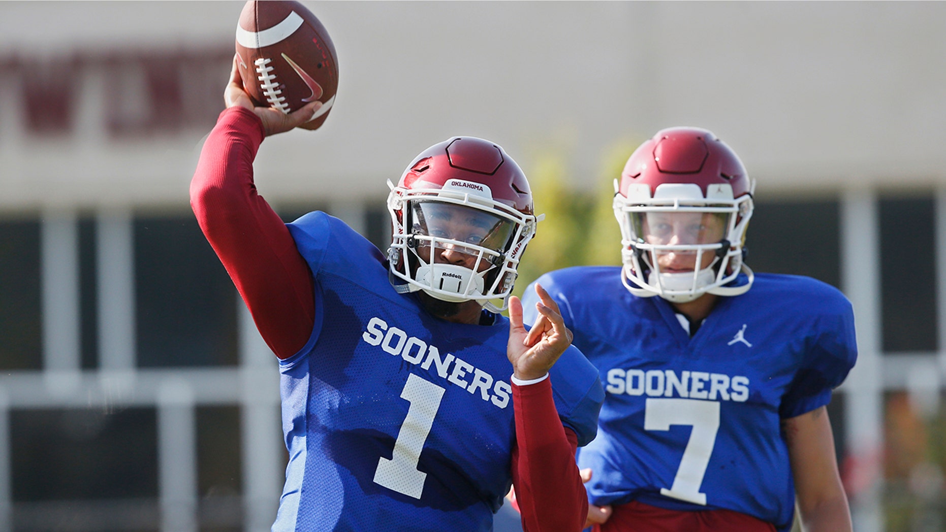 FILE - In this Monday, Aug. 5, 2019, file photo, Oklahoma quarterback Jalen Hurts (1) throws as quarterback Spencer Rattler watches during the NCAA college football team's practice in Norman, Okla. Oklahoma coach Lincoln Riley has chosen Hurts as his starting quarterback for the Sept. 1 season opener against Houston over Rattler and Tanner Mordecai. (AP Photo/Sue Ogrocki, File)