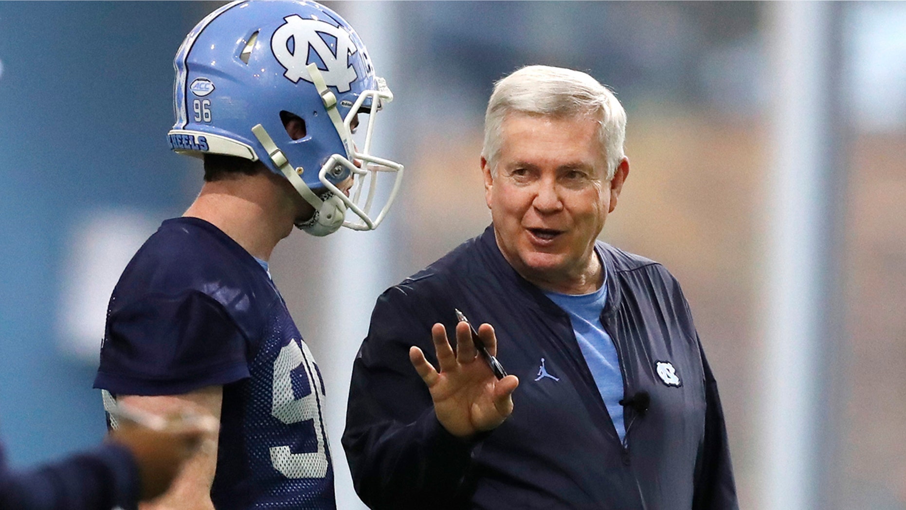 FILE - In this March 3, 2019, file photo, North Carolina head coach Mack Brown talks with Cooper Graham (96) during UNC's first spring football practice, in Chapel Hill, N.C. Brown is savoring his return to coaching in a second stint with the Tar Heels. (Ethan Hyman/The News & Observer via AP, File)