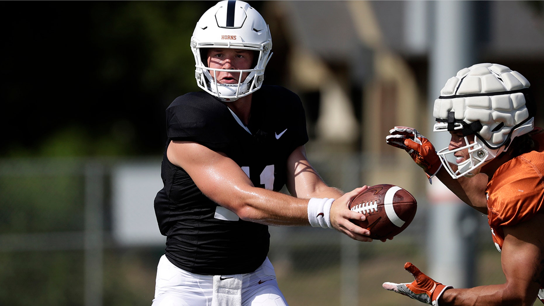 Texas quarterback Sam Ehlinger, left, and running back Jordan Whittington, right, take part in a morning practice at the team's facility in Austin, Texas, Wednesday, Aug. 7, 2019. (AP Photo/Eric Gay)