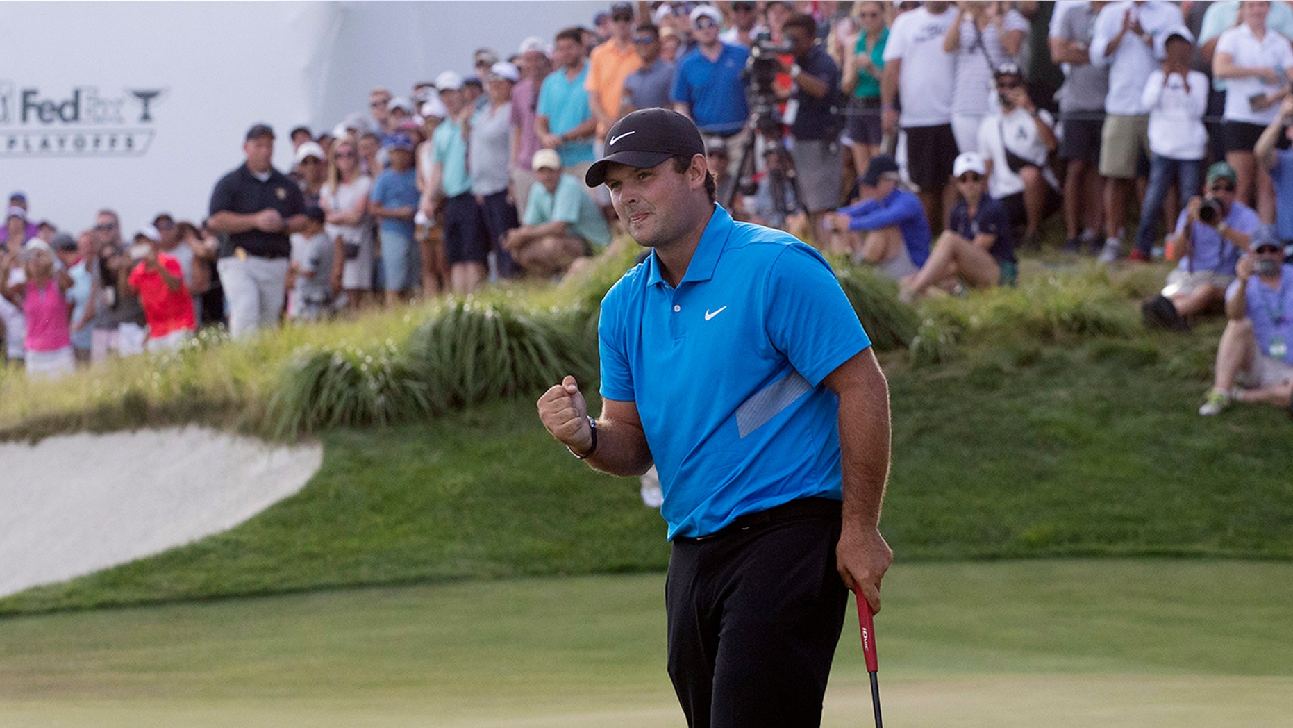 Patrick Reed pumps his fist on the 18th hole as he wins on the Northern Trust golf tournament at Liberty National Golf Course, Sunday, Aug. 11, 2019, in Jersey City, N.J. (AP Photo/Mark Lennihan)