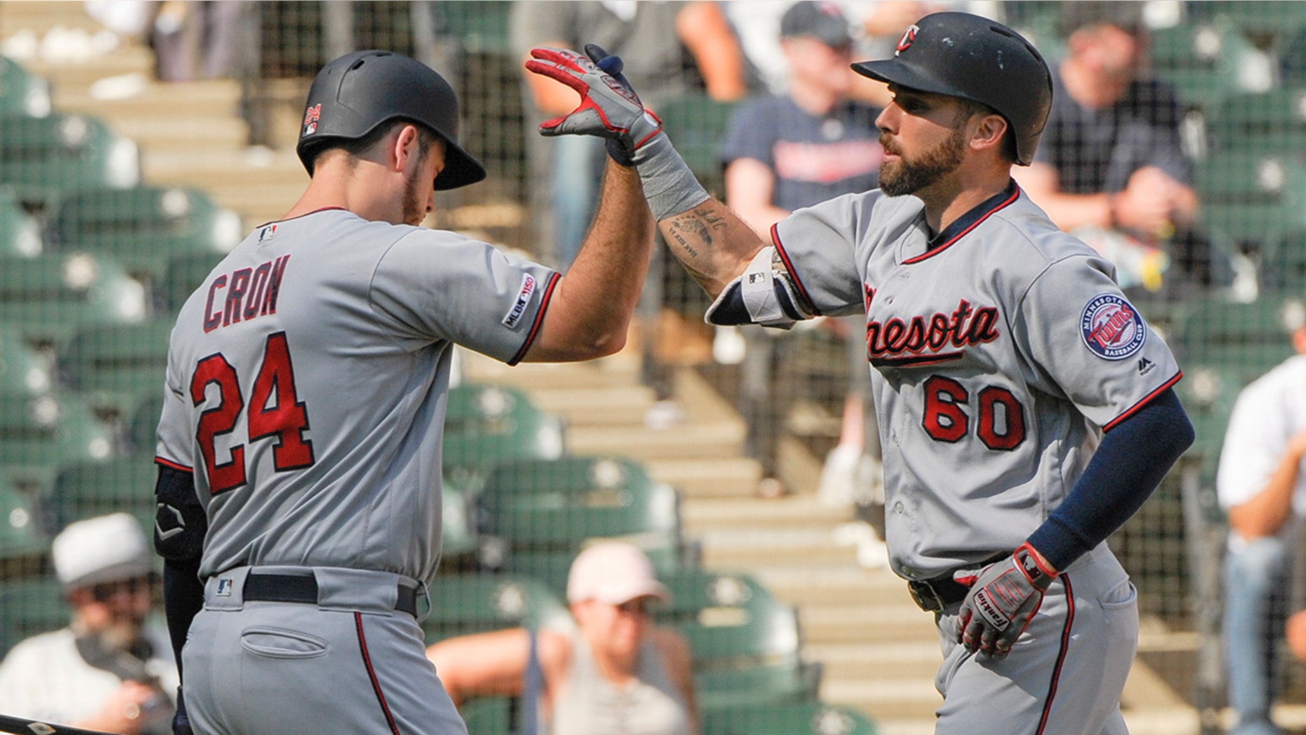 Minnesota Twins' C.J. Cron (24) congratulates Jake Cave (60) on his seventh-inning home run against the Chicago White Sox during a baseball game Thursday, Aug. 29, 2019, in Chicago. (AP Photo/Mark Black)
