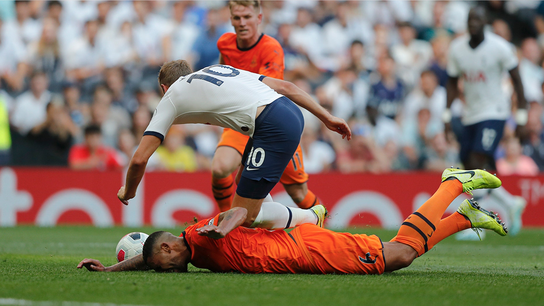 Tottenham's Harry Kane falls after he was tackled by Newcastle's Jamaal Lascelles during the English Premier League soccer match between Tottenham Hotspur and Newcastle United at Tottenham Hotspur Stadium in London, Sunday, Aug. 25, 2019.(AP Photo/Frank Augstein)