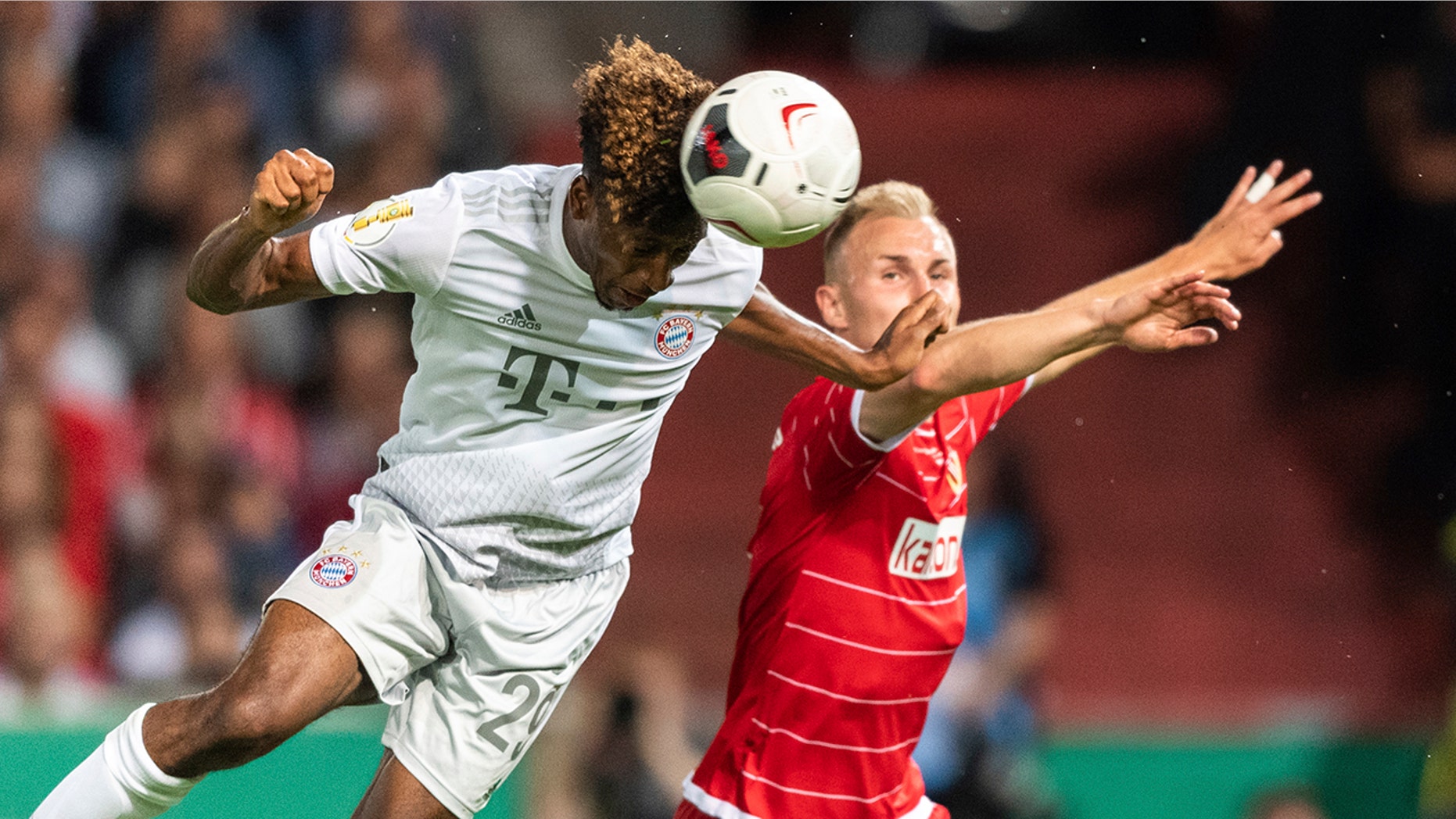 Munich's Kingsley Coman, left, and Tobias Hasse from Cottbus challenge for the ball during the German soccer cup, DFB Pokal, first Round match between FC Energie Cottbus and FC Bayern Munich in Cottbus, Germany, Monday, Aug. 12, 2019. Foto: Robert Michael/dpa via AP)