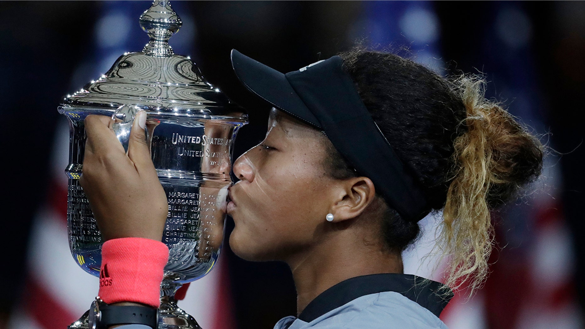 FILE - In this Sept. 8, 2018, file photo, Naomi Osaka, of Japan, kisses the trophy after defeating Naomi Osaka, of Japan, in the women's final of the U.S. Open tennis tournament in New York. Osaka is ranked No. 1 heading into the U.S. Open, where she will attempt to defend a Grand Slam title for the first time. (AP Photo/Julio Cortez, File)