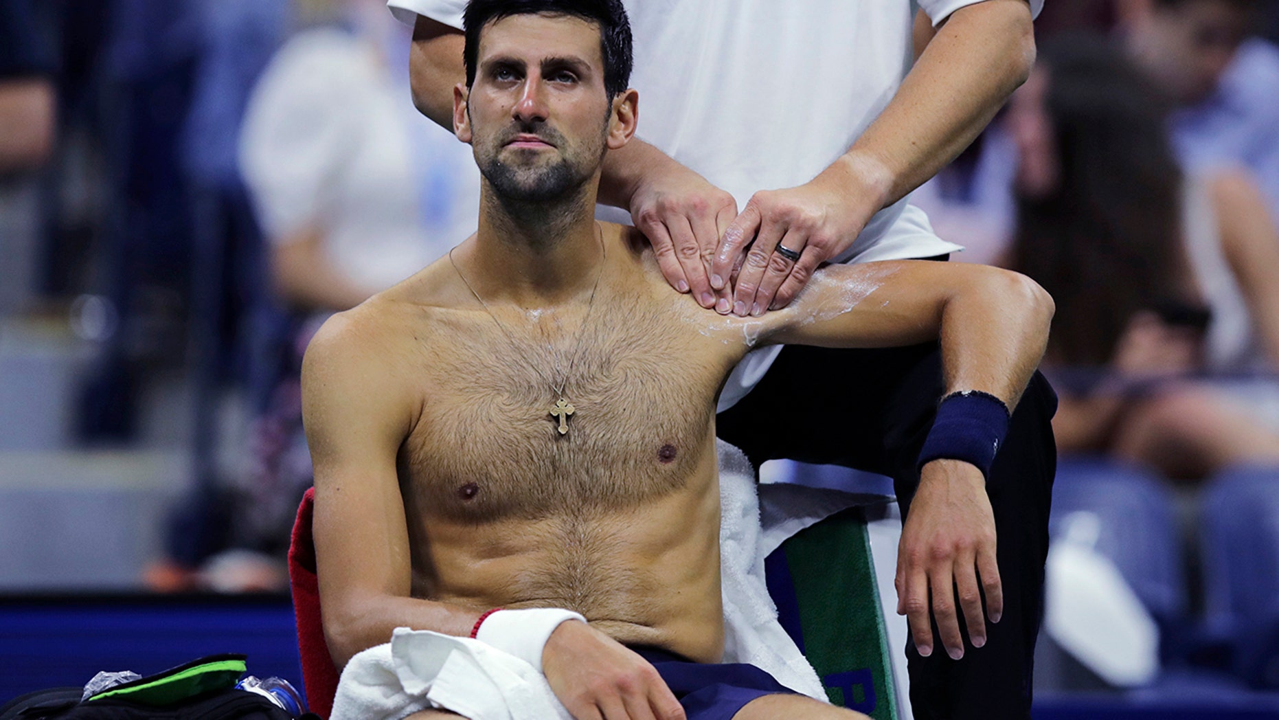 Novak Djokovic, of Serbia, receives treatment from a trainer during his match against Juan Ignacio Londero, of Argentina, during the second round of the U.S. Open tennis tournament in New York, Wednesday, Aug. 28, 2019. (AP Photo/Charles Krupa)