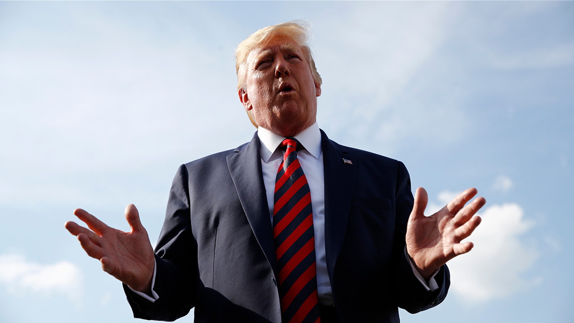 President Donald Trump speaks with reporters before boarding Air Force One with first lady Melania Trump at Morristown Municipal Airport in Morristown, N.J.(AP Photo/Patrick Semansky)