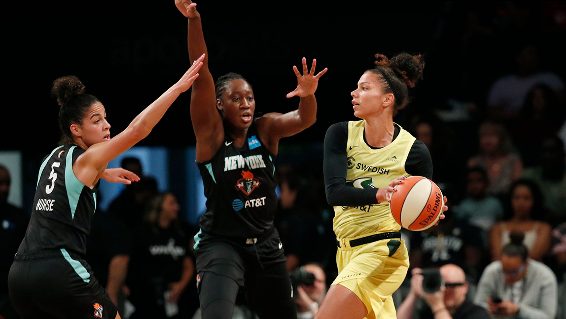 Seattle Storm forward Alysha Clark, right, passes as New York Liberty guard Kia Nurse, left, and center Tina Charles,center, defend during the first half of a WNBA basketball game, Sunday, Aug. 11, 2019, in New York. (AP Photo/Kathy Willens)