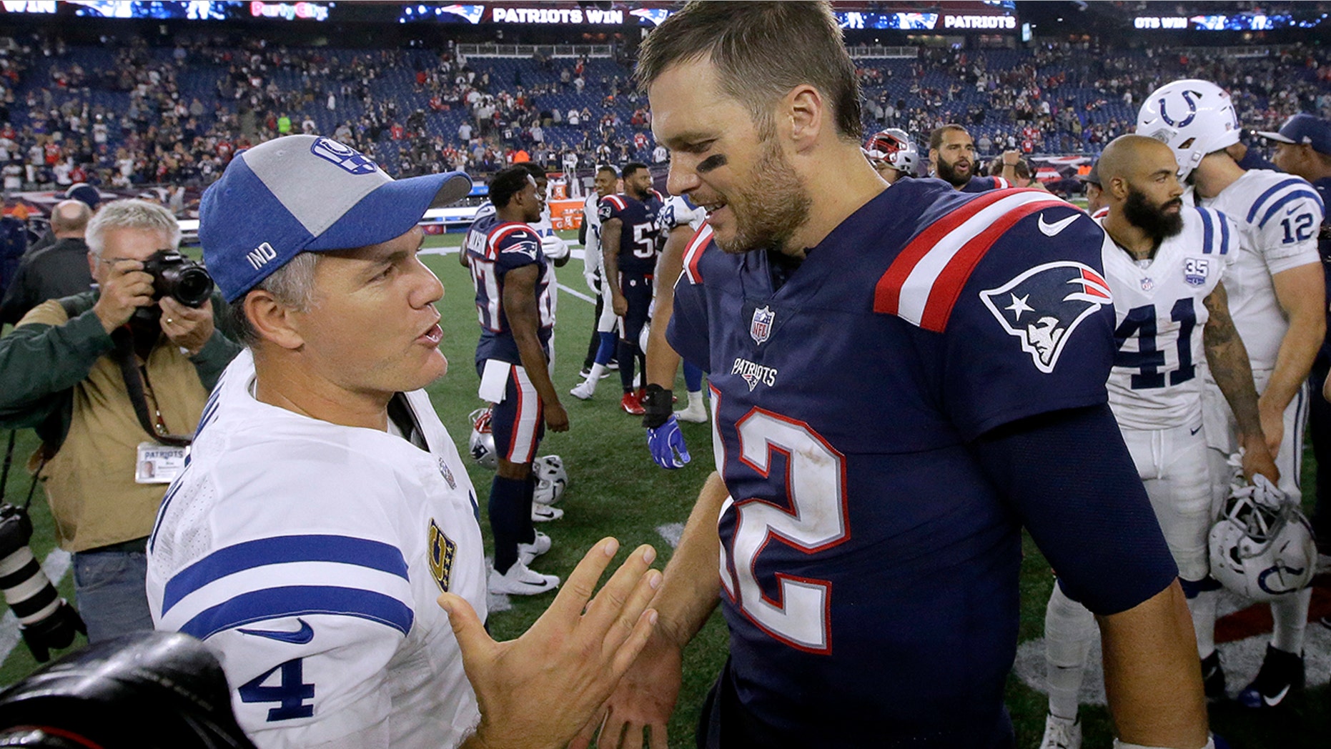 FILE - In this Oct. 4, 2018, file photo, Indianapolis Colts kicker Adam Vinatieri, left, and New England Patriots quarterback Tom Brady speak at midfield after an NFL football game in Foxborough, Mass. The NFL isn’t exclusively for the young. From fortysomethings such as Tom Brady and Adam Vinatieri to those nearing a fourth decade from Eli Manning, Philip Rivers and Terrell Suggs, there’s still a place for the aged in football. (AP Photo/Steven Senne, File)