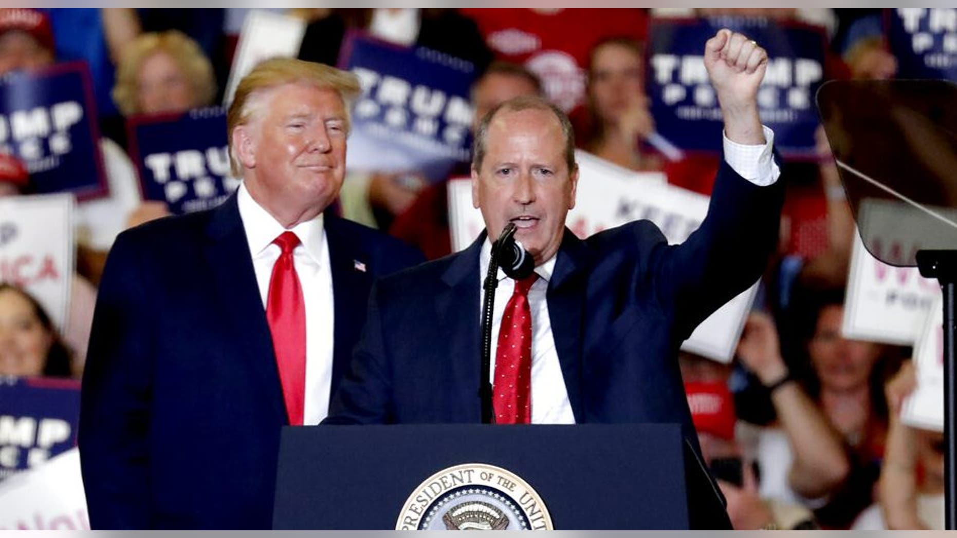President Donald Trump, left, gives his support to Dan Bishop, right, a Republican running for the special North Carolina 9th District U.S. Congressional race as he speaks at a rally in Fayetteville, N.C., Monday, Sept. 9, 2019. (AP Photo/Chris Seward)