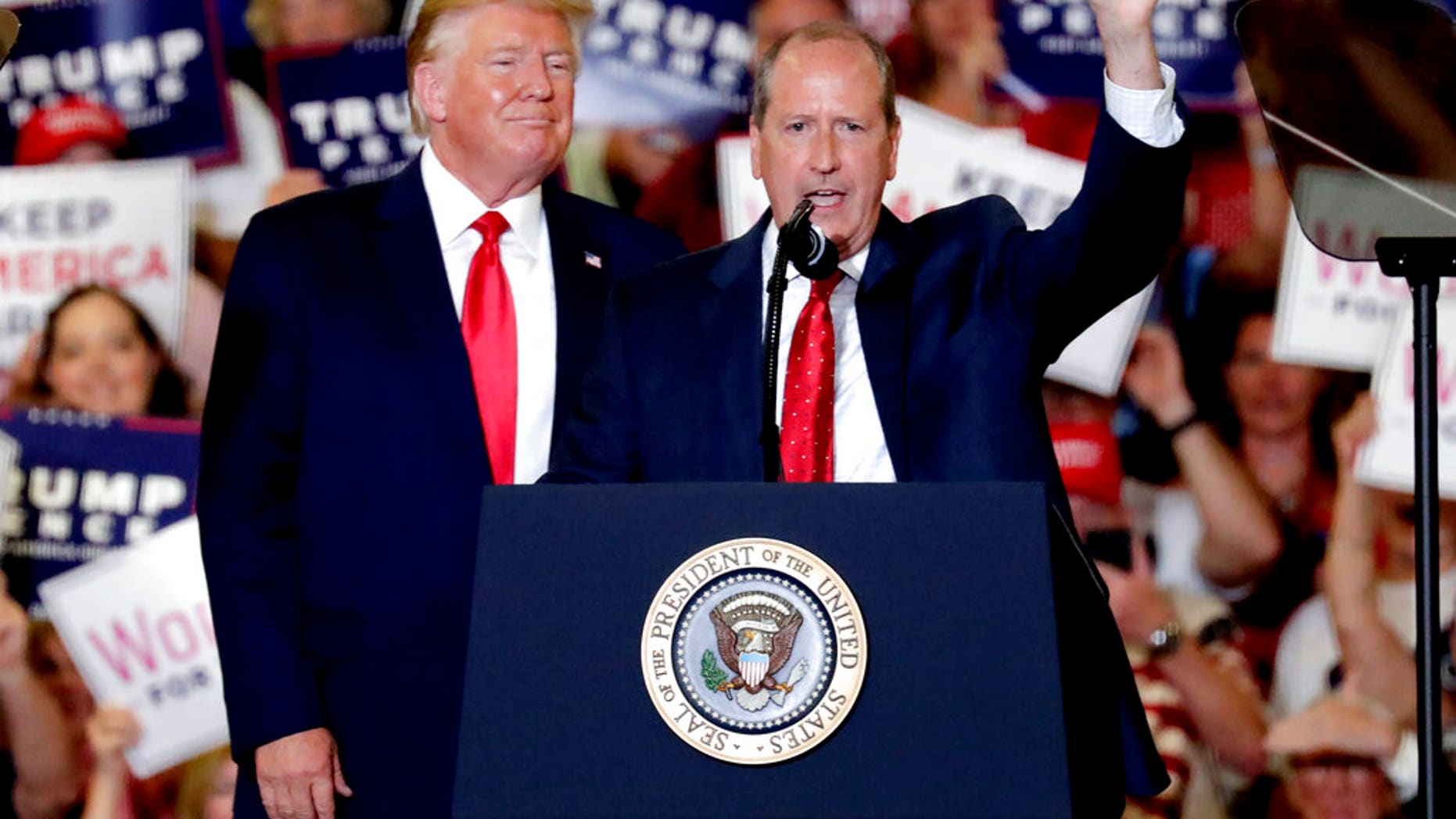 President Donald Trump, left, gives his support to Dan Bishop, right, a Republican running for the special North Carolina 9th District U.S. Congressional race as he speaks at a rally in Fayetteville, N.C., Monday, Sept. 9, 2019. (AP Photo/Chris Seward)