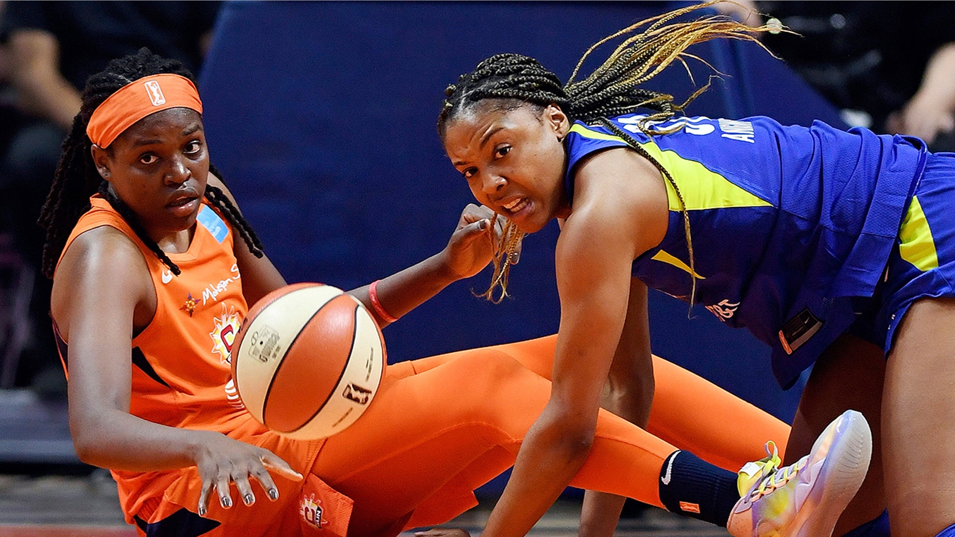 Connecticut Sun center Jonquel Jones, left, and Dallas Wings center Kristine Anigwe dive to the floor after a loose ball during a WNBA basketball game Wednesday, Sept. 4, 2019, in Uncasville, Conn. (Sean D. Elliot/The Day via AP)