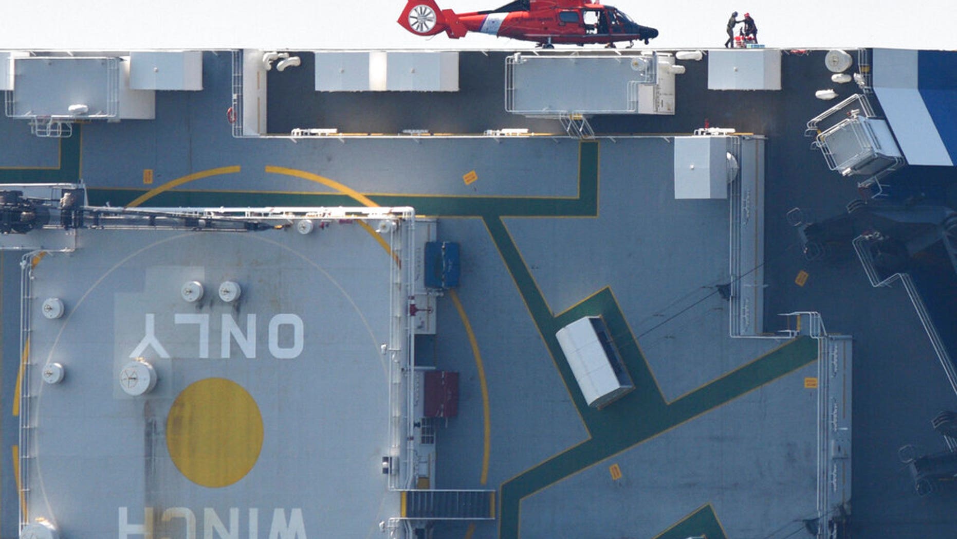 Members of the U.S. Coast Guard unload supplies from a Coast Guard helicopter from the side of the cargo ship Golden Ray, Monday(Bobby Haven/The Brunswick News via AP)