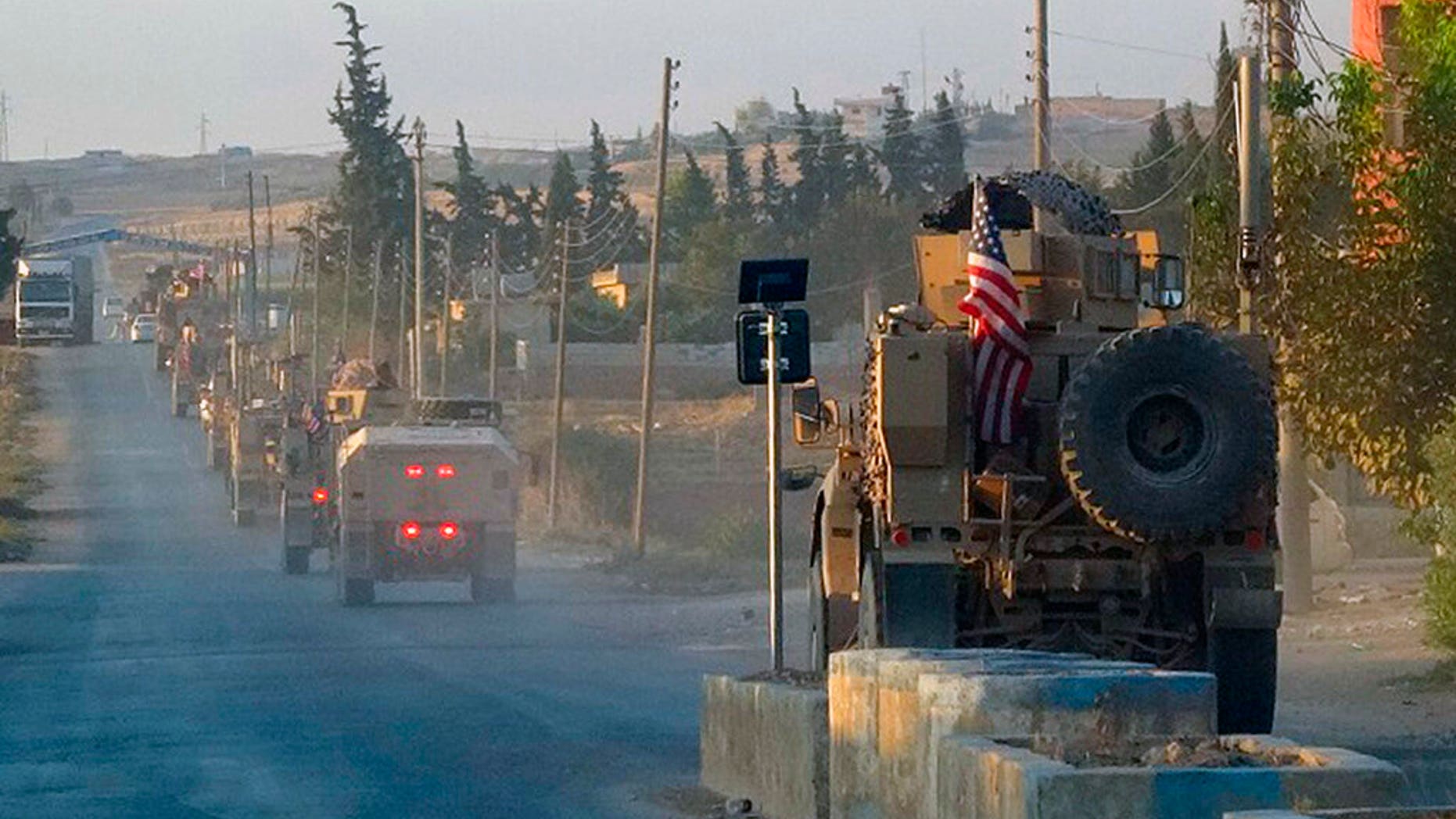 In this image provided by Hawar News Agency, ANHA, U.S. military vehicles travel down a main road in northeast Syria, Monday, Oct. 7, 2019. U.S.-backed Kurdish-led forces in Syria said American troops began withdrawing Monday from their positions along Turkey's border in northeastern Syria, ahead of an anticipated Turkish invasion. (ANHA via AP)