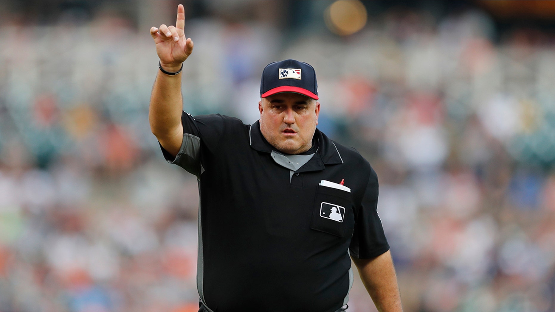 In this July 5, 2019, photo, home plate umpire Eric Cooper signals during the third inning of a baseball game between the Detroit Tigers and the Boston Red Sox in Detroit. Cooper, the Major League Baseball umpire who worked the AL Division Series two weeks ago, has died. He was 52. Commissioner Rob Manfred announced Cooper's death Sunday, Oct. 20. Cooper died after having a blood clot. (AP Photo/Carlos Osorio)