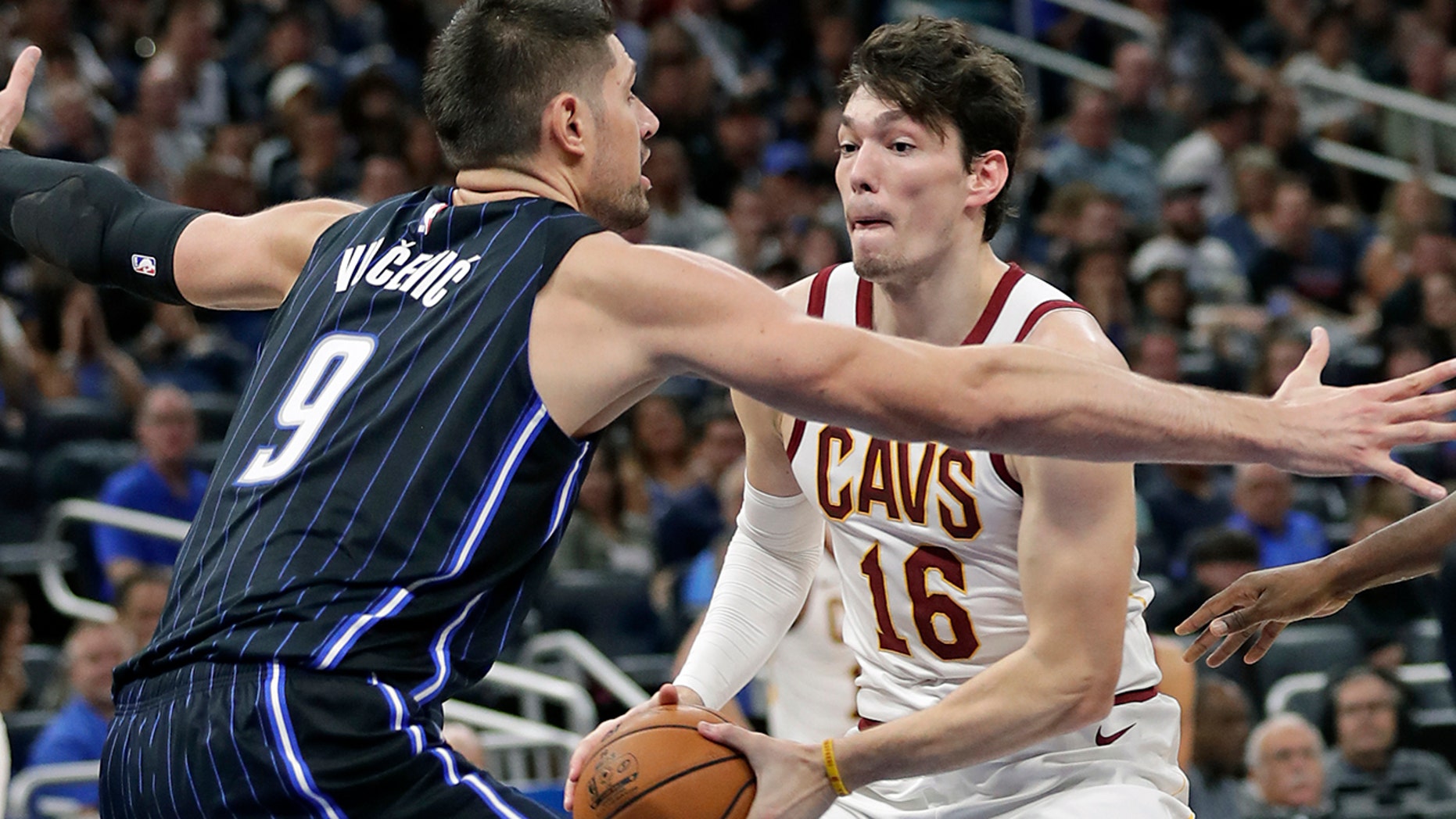 Cleveland Cavaliers forward Cedi Osman (16) looks for a way around Orlando Magic's Nikola Vucevic (9) during the second half of an NBA basketball game Wednesday, Oct. 23, 2019, in Orlando, Fla. (AP Photo/John Raoux)