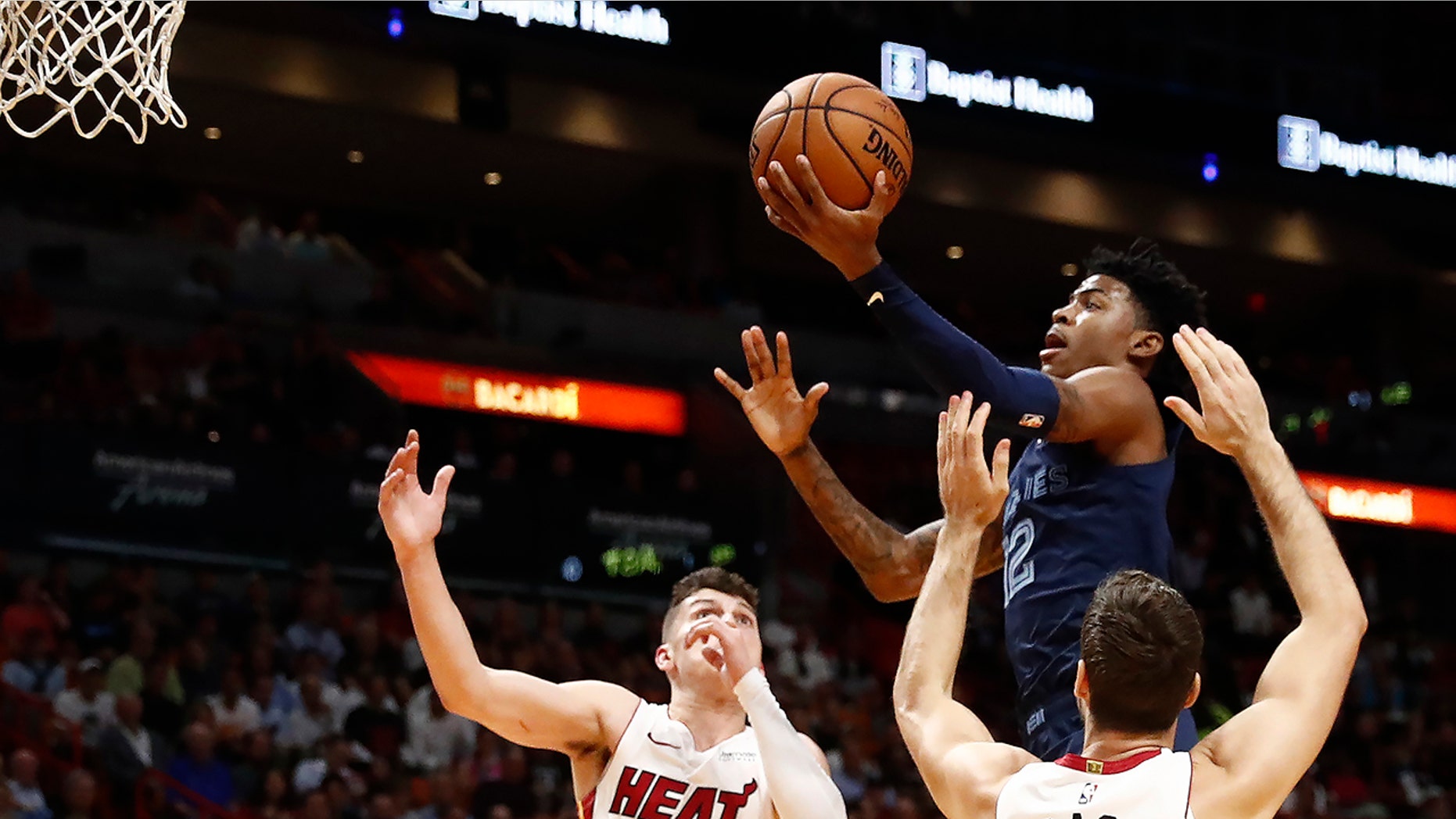 Memphis Grizzlies' Ja Morant (12) shoots as Miami Heat guards Tyler Herro (14) and Goran Dragic (7) defend during the first half of an NBA basketball game Wednesday, Oct. 23, 2019, in Miami. (AP Photo/Brynn Anderson)
