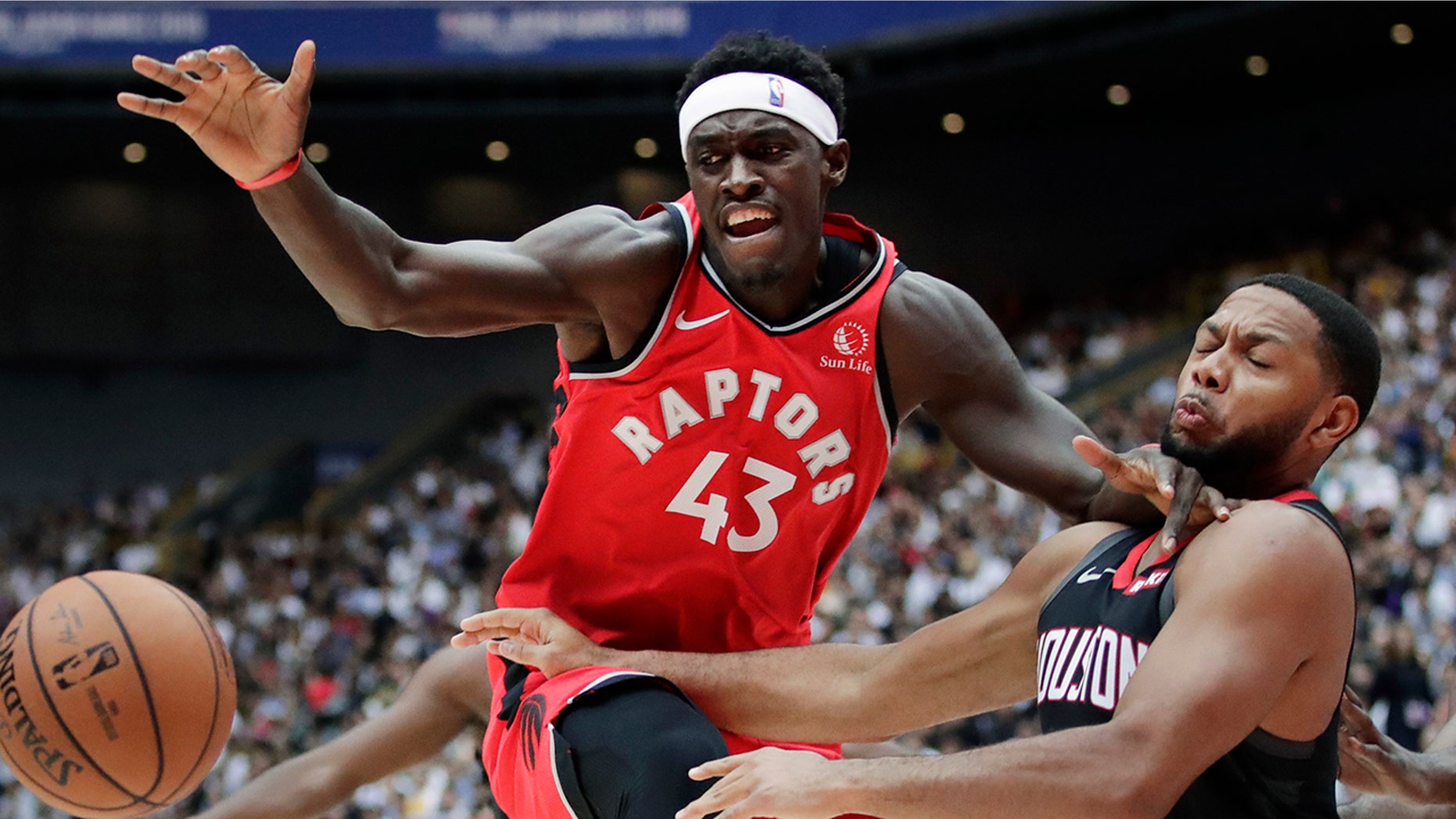Toronto Raptors' Pascal Siakam, left, fights for a loose ball with Houston Rockets' Eric Gordon during the first half of an NBA preseason basketball game Thursday, Oct. 10, 2019, in Saitama, near Tokyo. (AP Photo/Jae C. Hong)