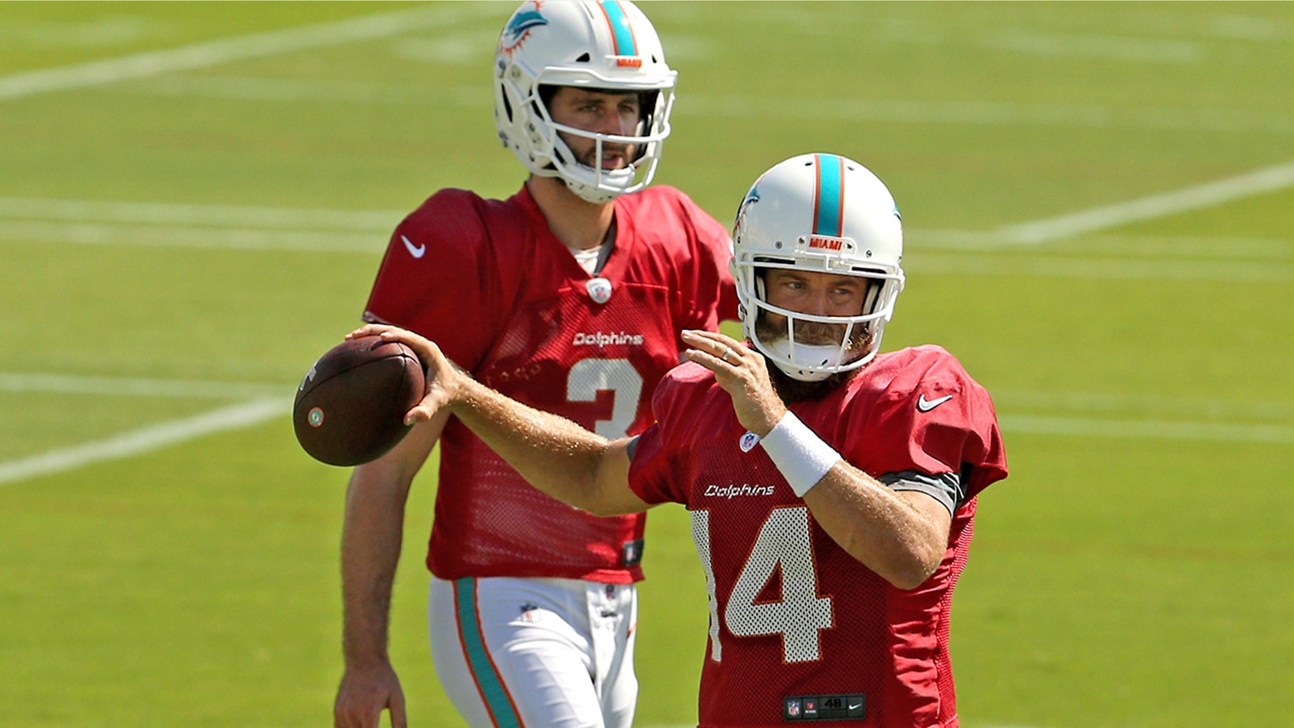 Miami Dolphins quarterbacks Ryan Fitzpatrick (14) and Josh Rosen (3) running drills during practice at the Baptist Health Training Facility at Nova Southeastern University on Wednesday, Oct. 16, 2019, in Davie, Fla., in preparation for their game against the Buffalo Bills on Sunday. (David Santiago/Miami Herald via AP)